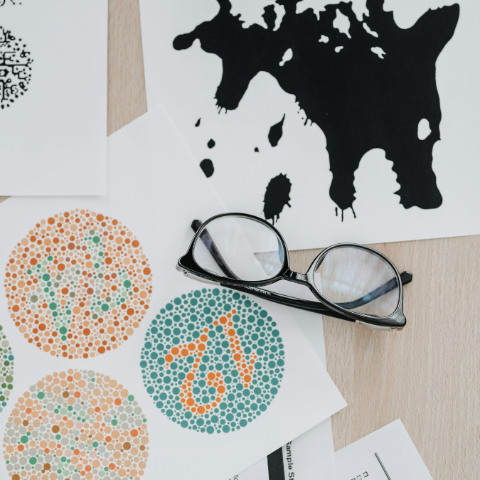 Glasses resting on visual pattern cards, representing noticing patterns and themes in a mental health vision board