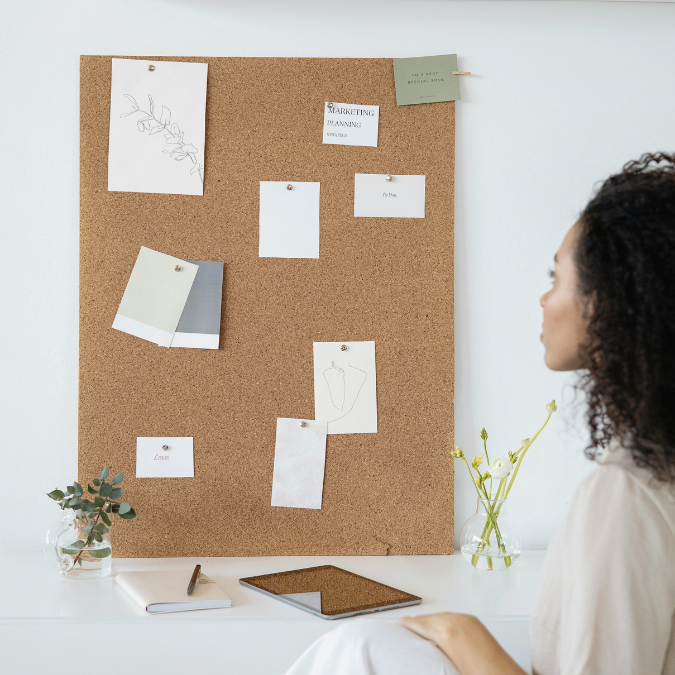 Minimal cork board with pinned notes and images, representing a simple mental health vision board setup