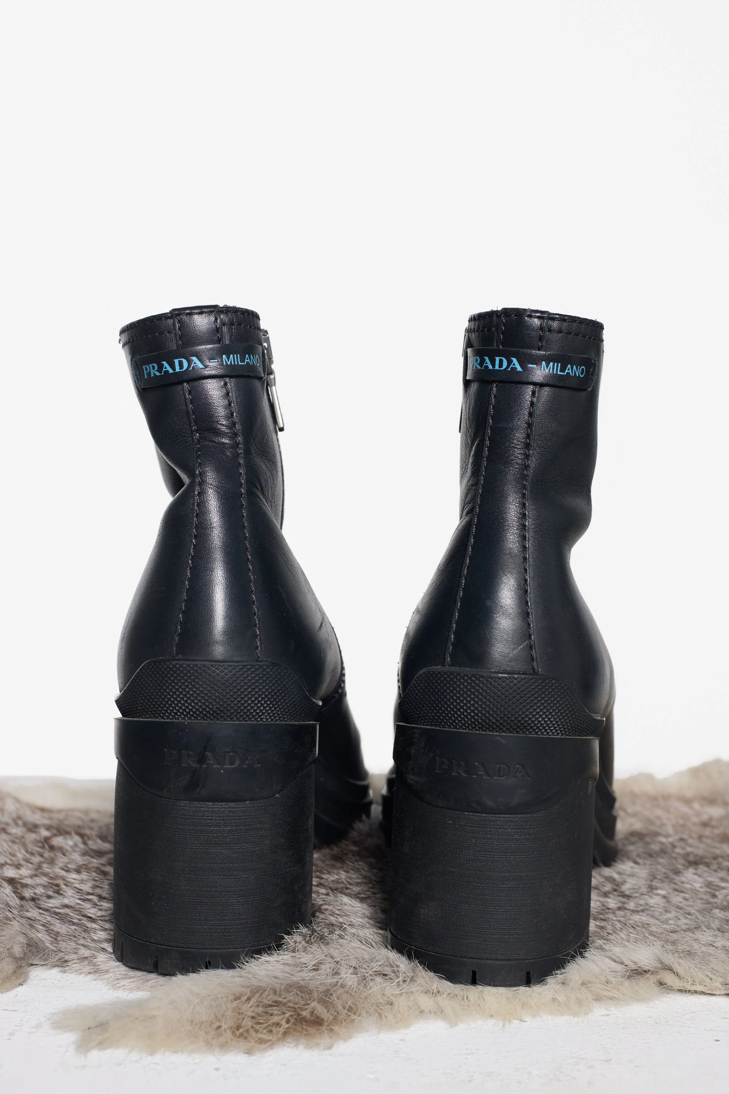 Back view of Prada leather boots with logo detailing and chunky block heels