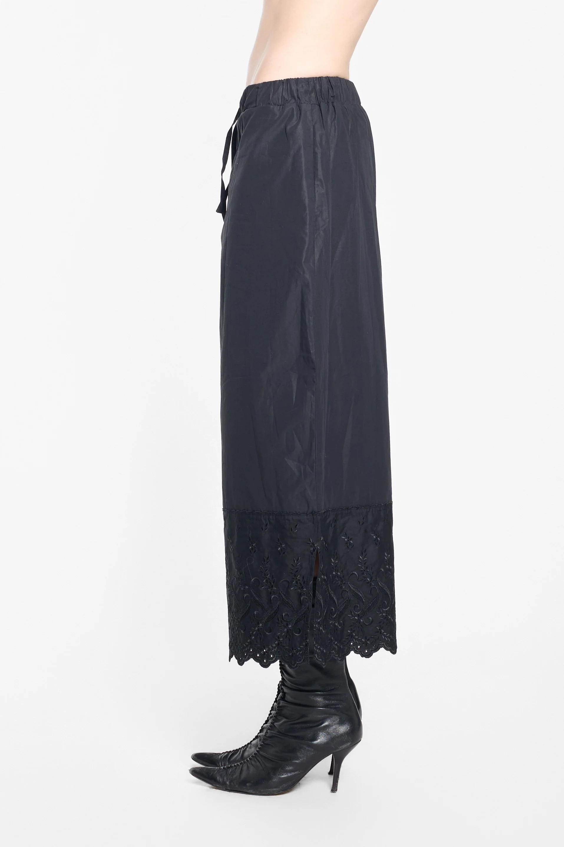 Side view of Simone Rocha black cotton broderie trousers