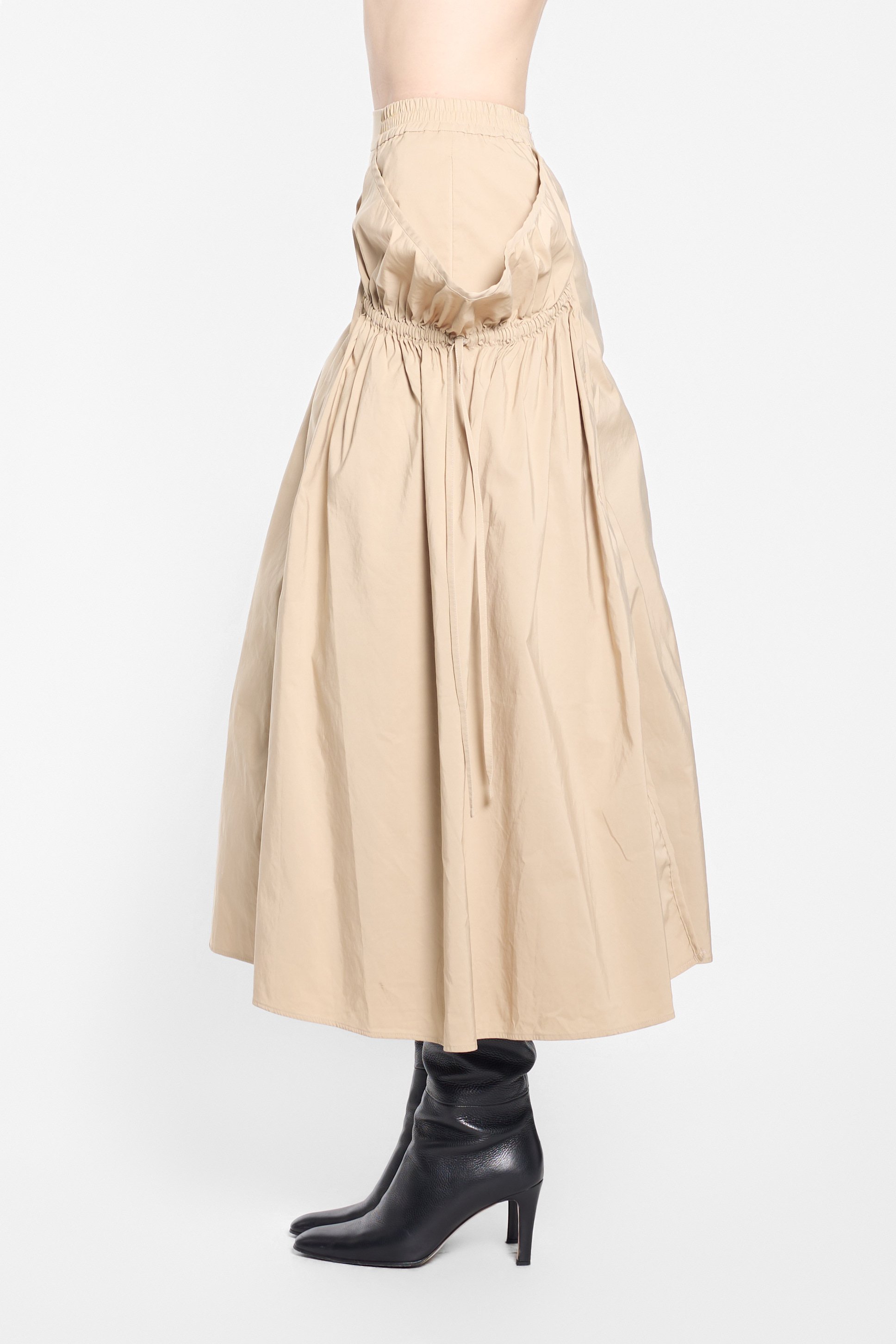 Side view of UN3D beige skirt with exaggerated sculptural volume