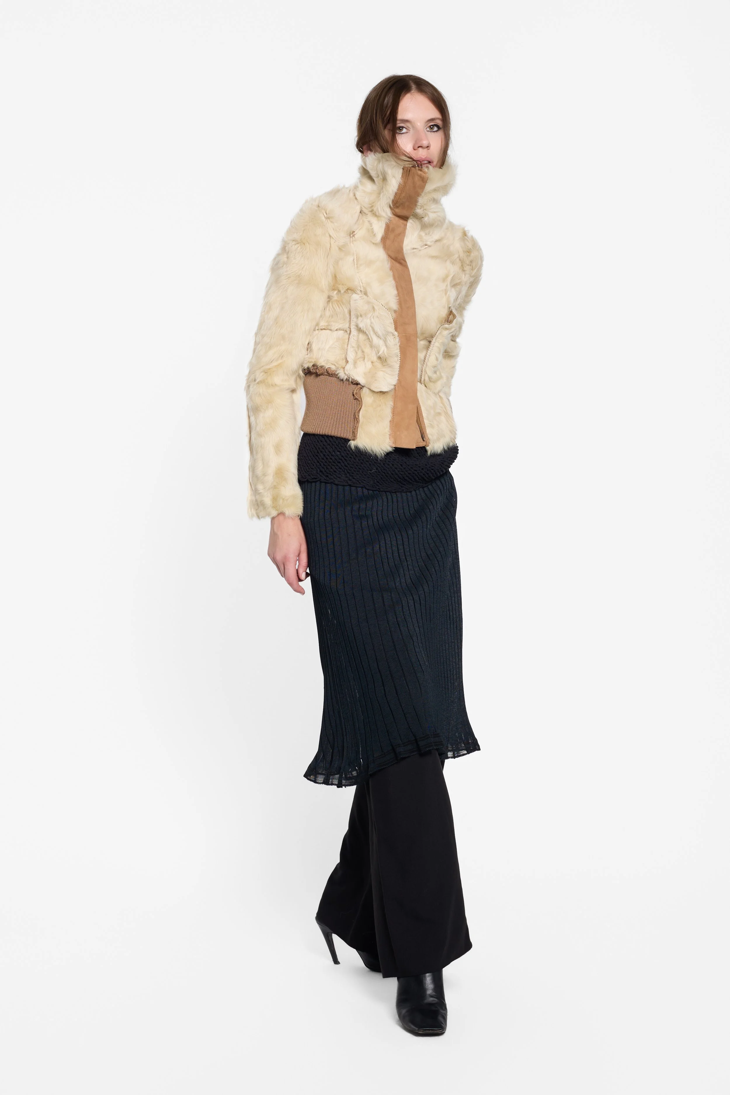 Full-length editorial view of Chelseagarb tan suede shearling jacket worn inside out to expose the fur.