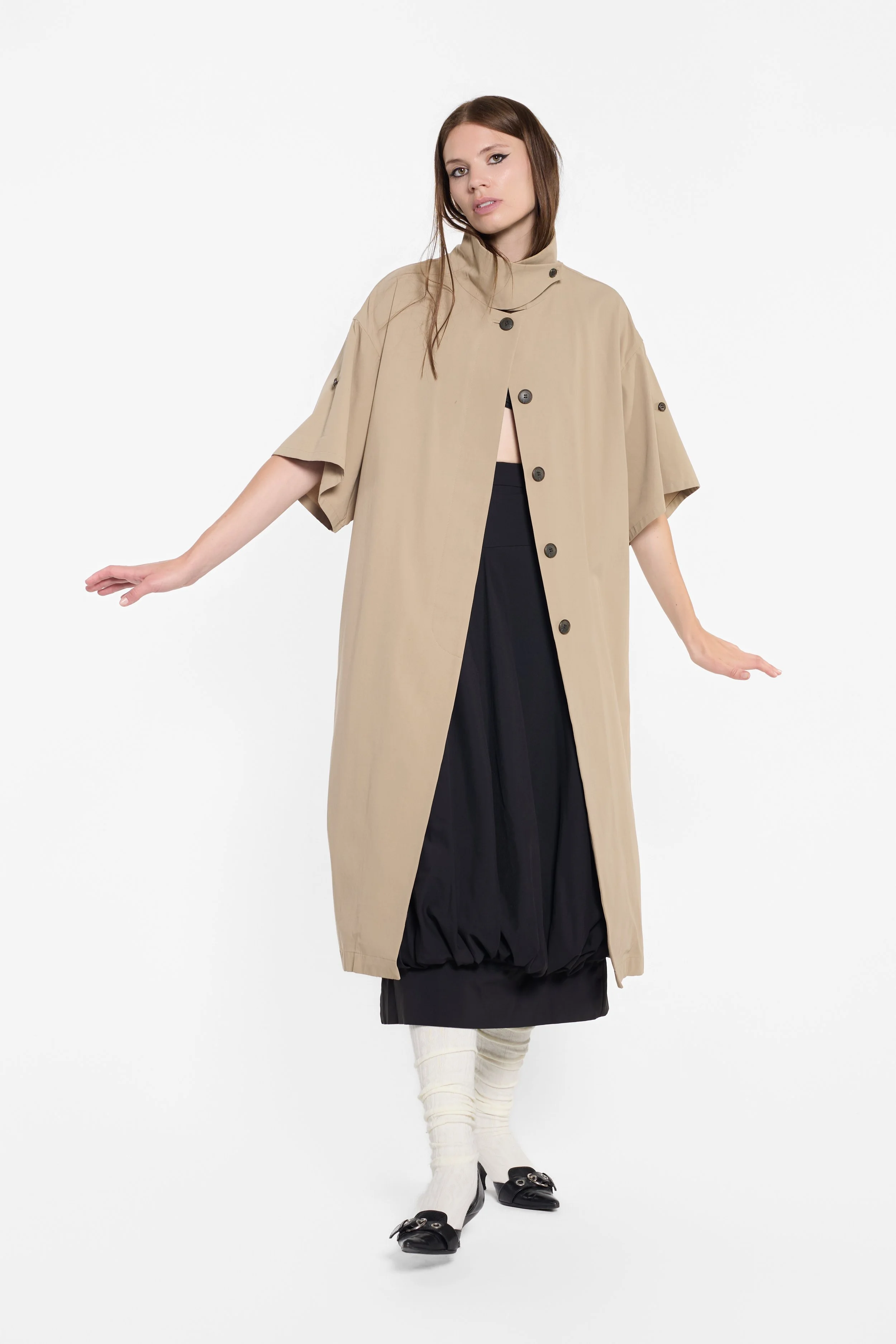 Black Japanese designer skirt with rounded gathered construction under a shrot sleeve camel trench coat by Japanese brand Column