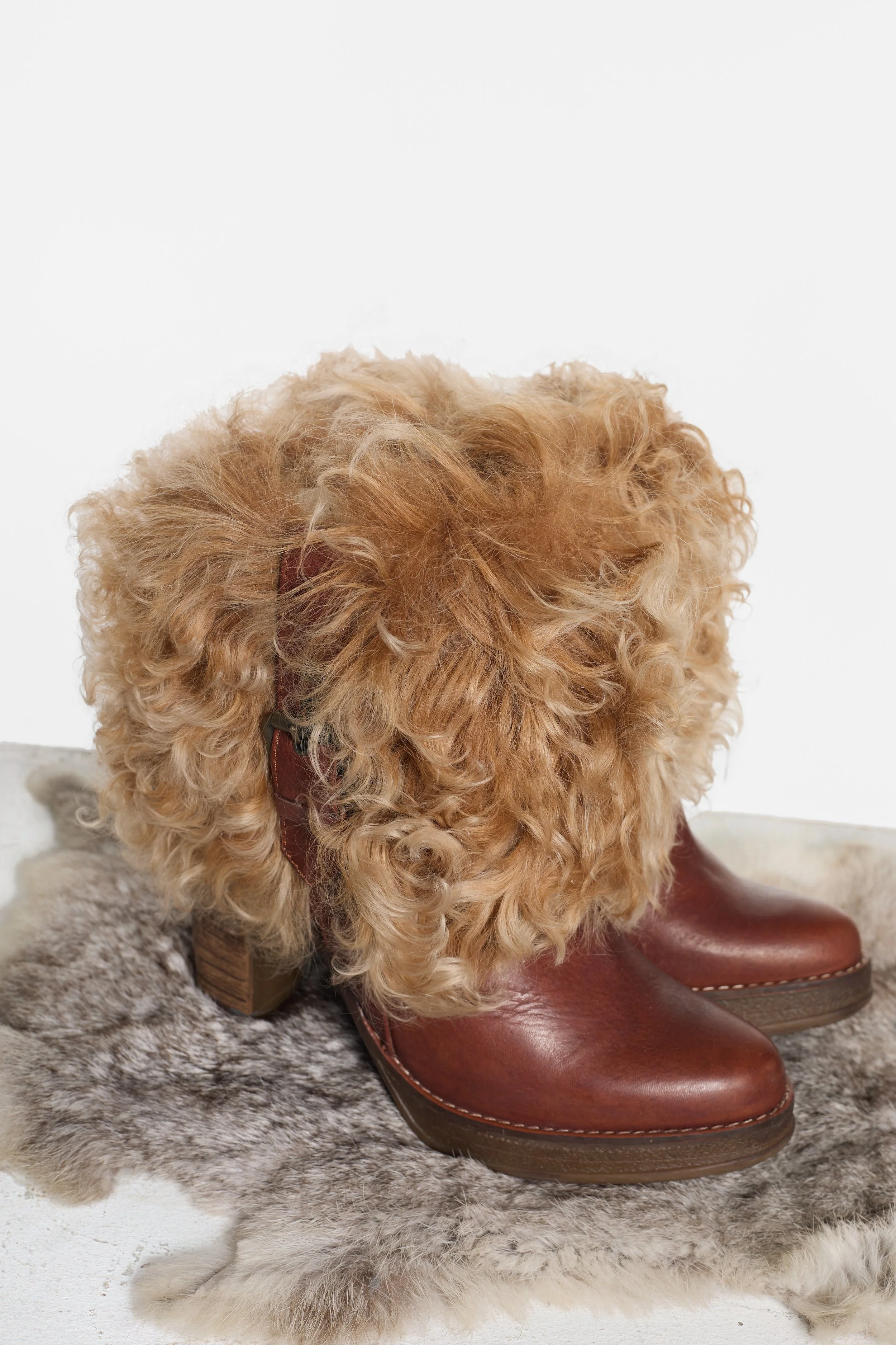 Brown leather designer ankle boots with exaggerated Mongolian fur