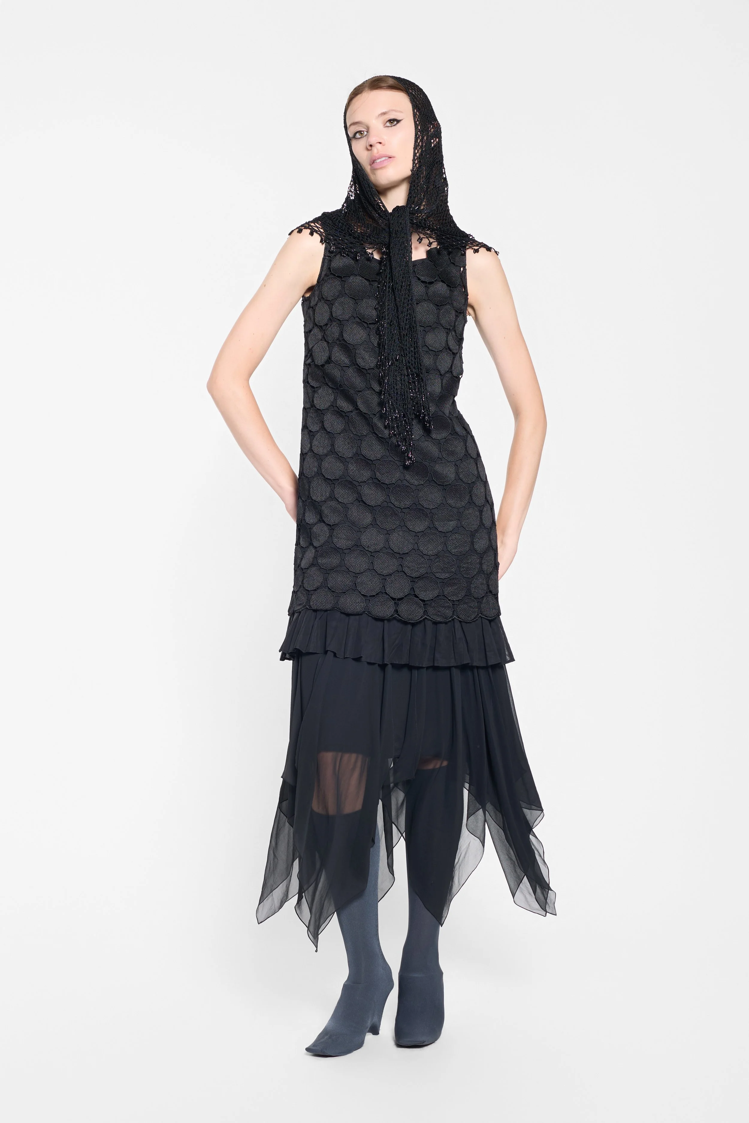 Model wearing LUXXM black disc appliqué mini dress