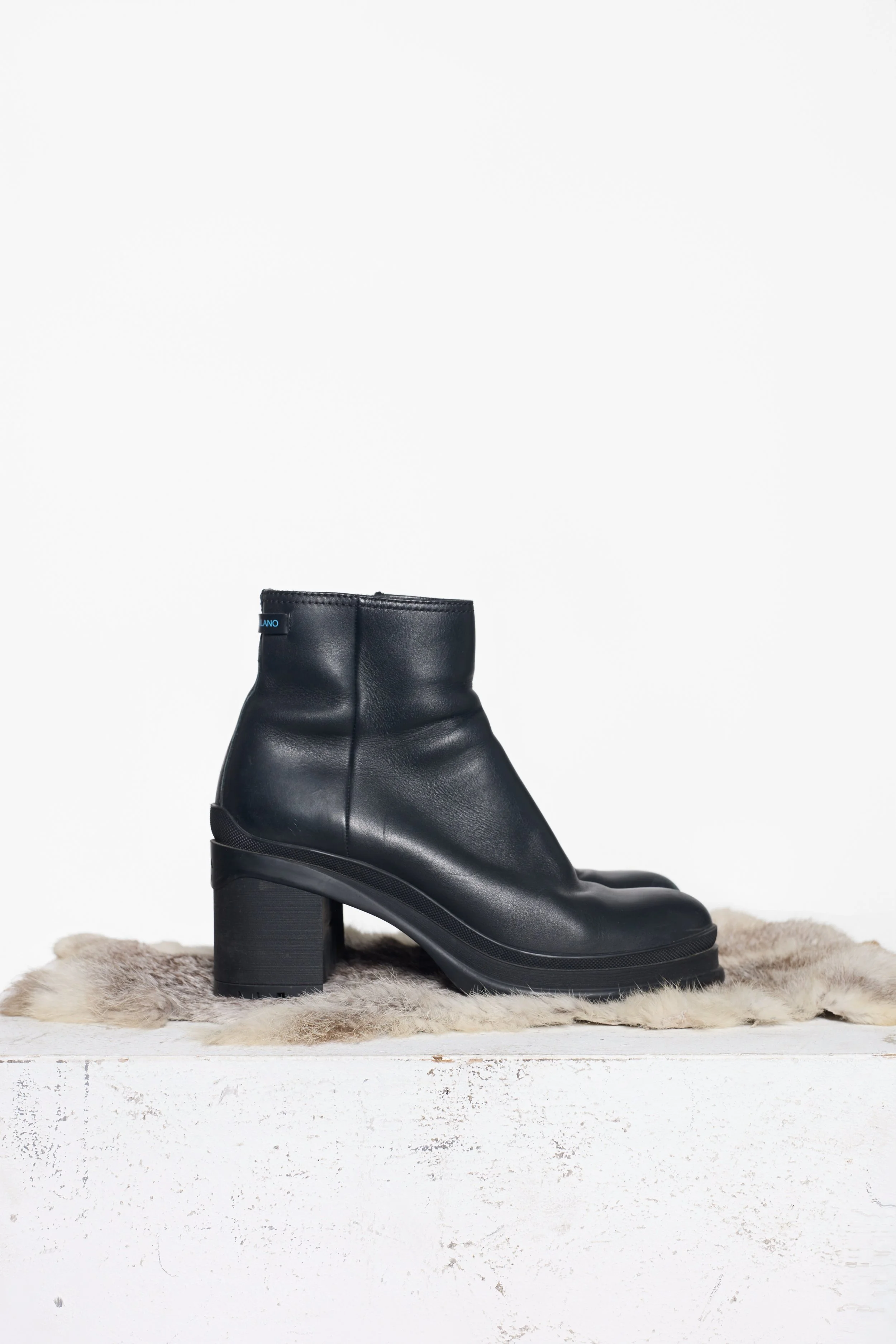 Side view of Prada black leather ankle boots with rubber tread sole