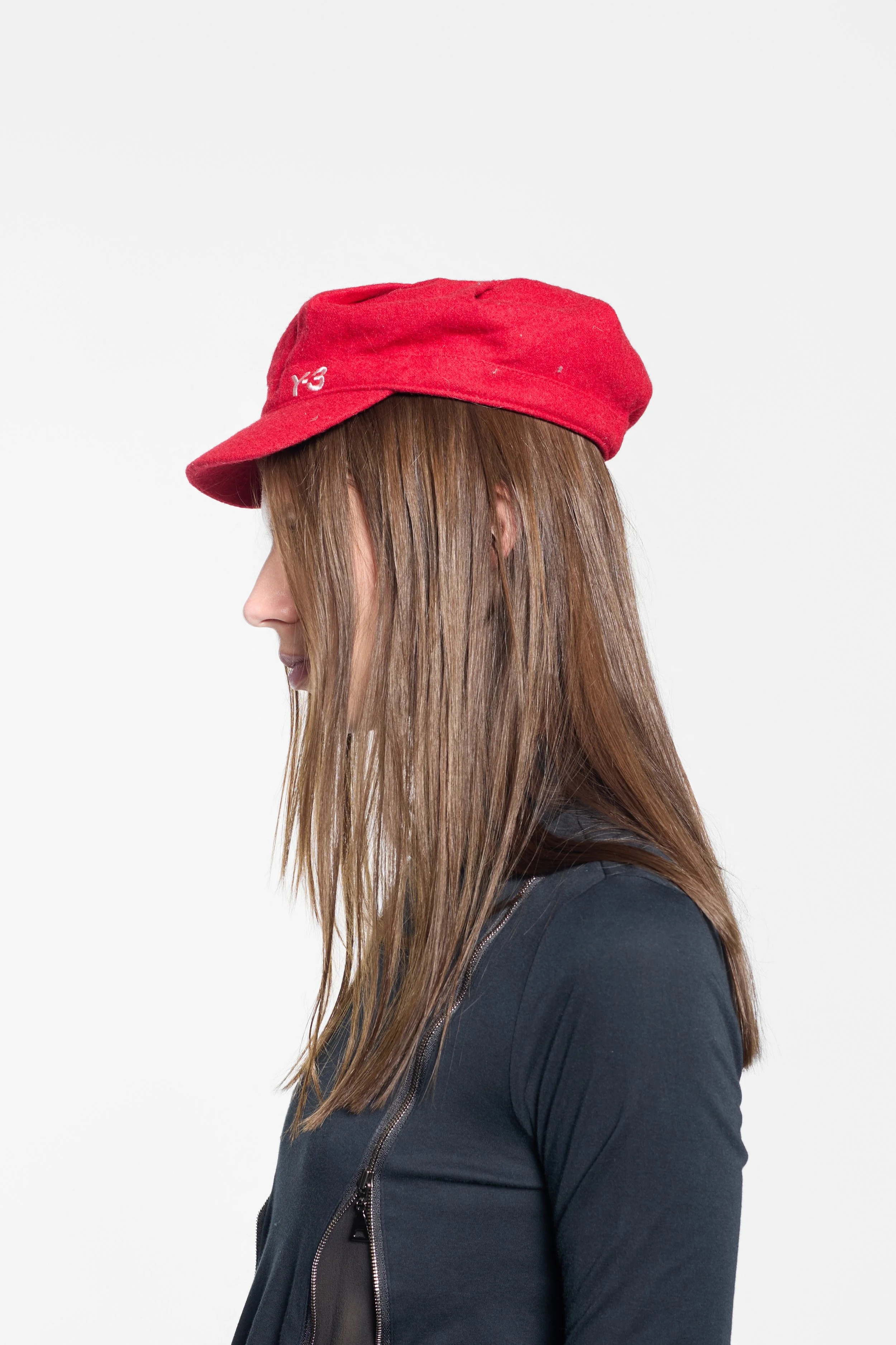 Side view of Y-3 wool cap showing short curved peak