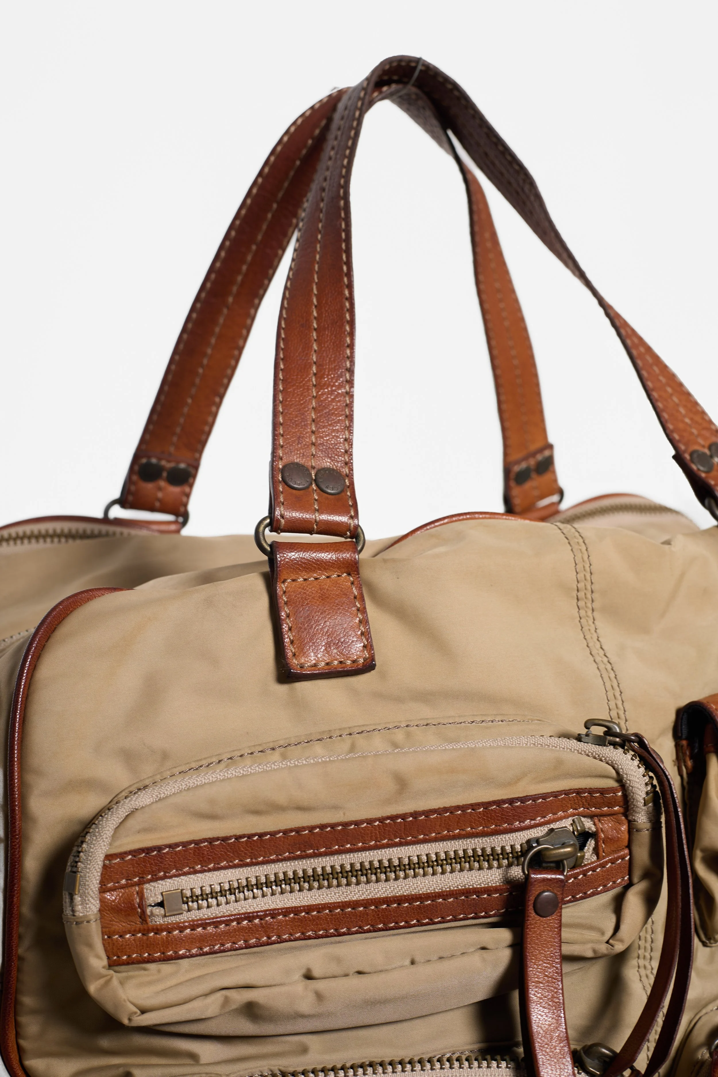 Close-up of zipped front pockets and brown leather trim on Y'SACCS bag