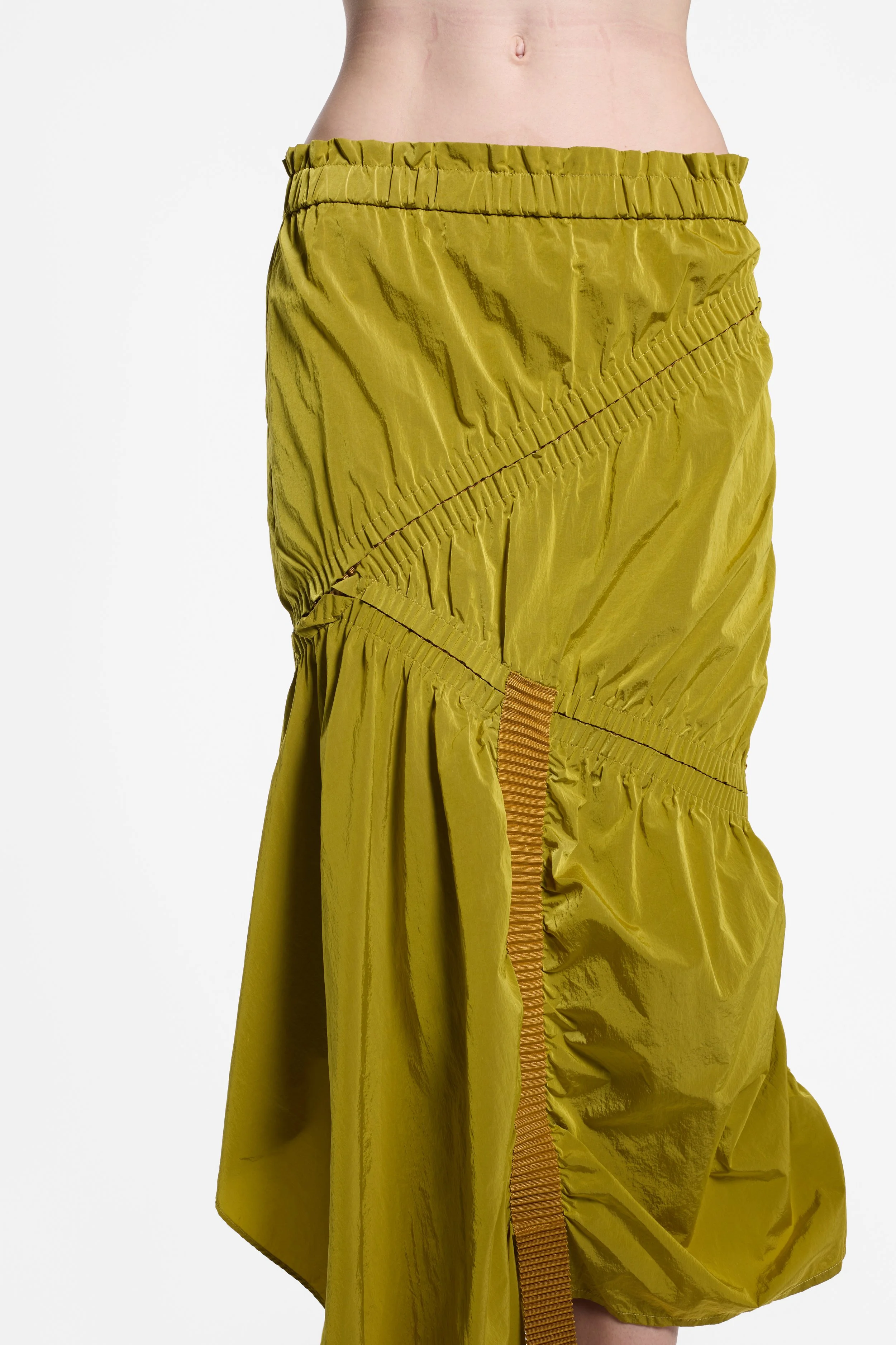 Detail of tan webbing and asymmetric layered hem on UN3D skirt