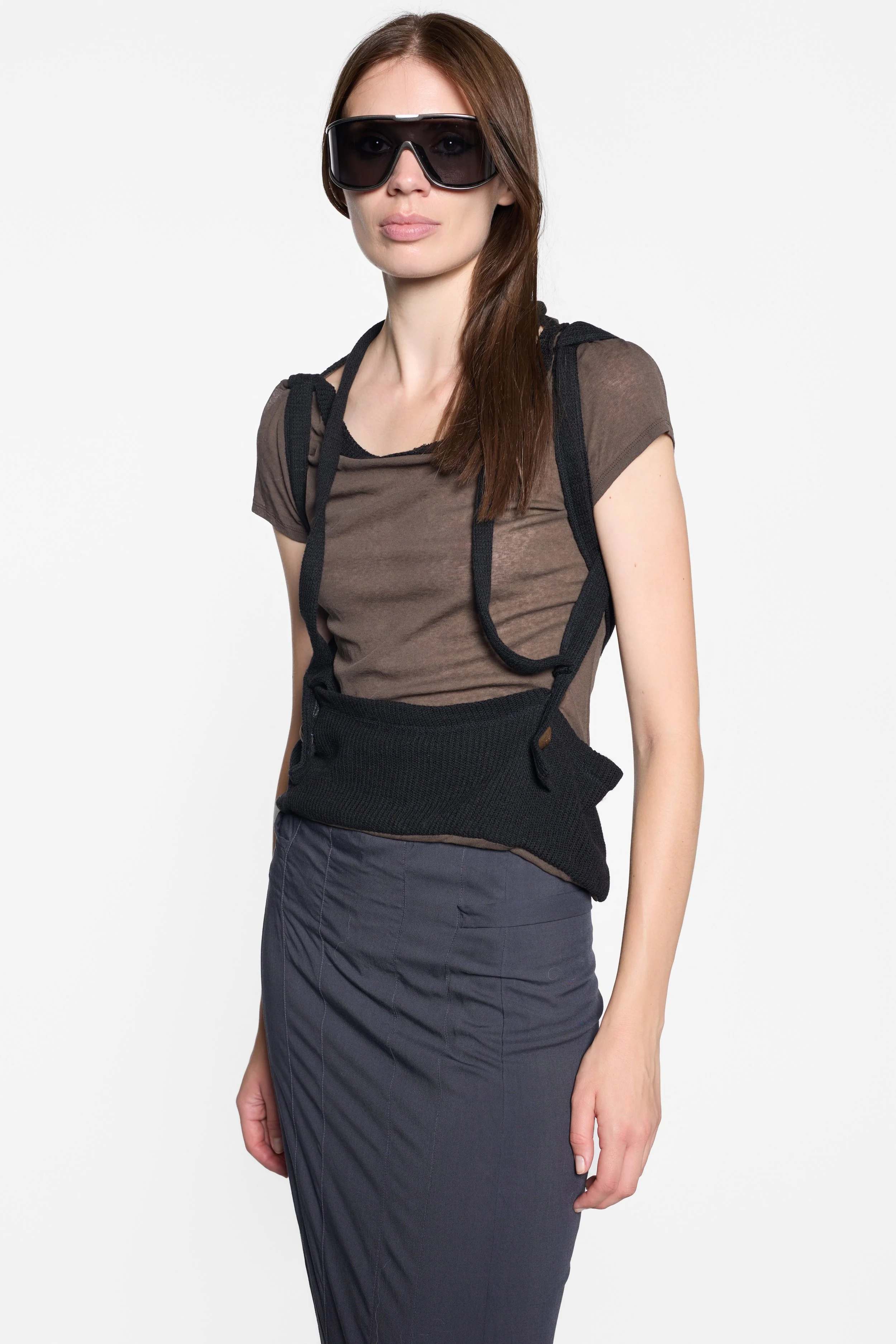 Model wearing LUXXM brown sheer knit top with black suspender overlay