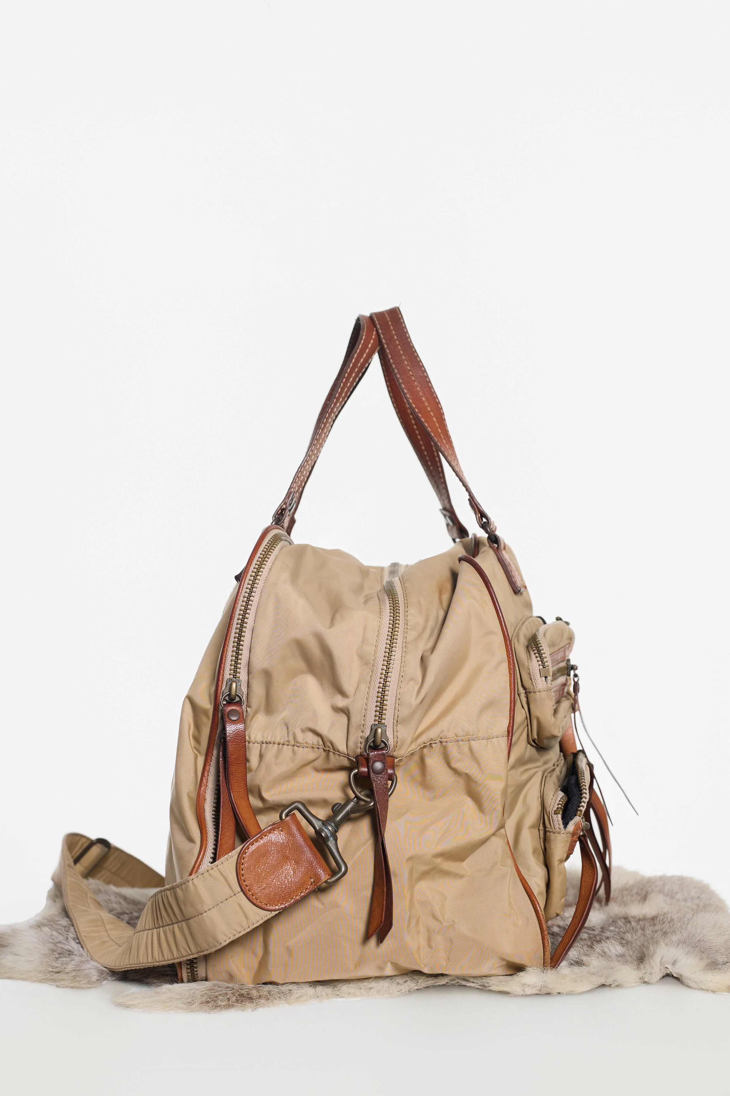 Side view of Y'SACCS khaki bag showing wide gusset and shoulder strap hardware