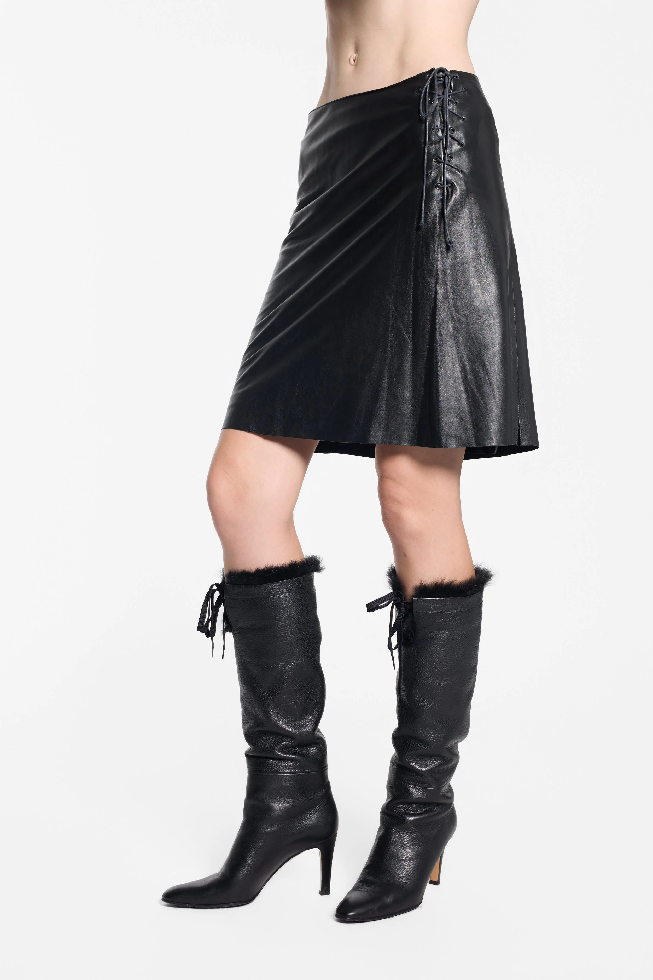Plein Sud black leather skirt, front draping and leather finish detail, alternate pose with leg