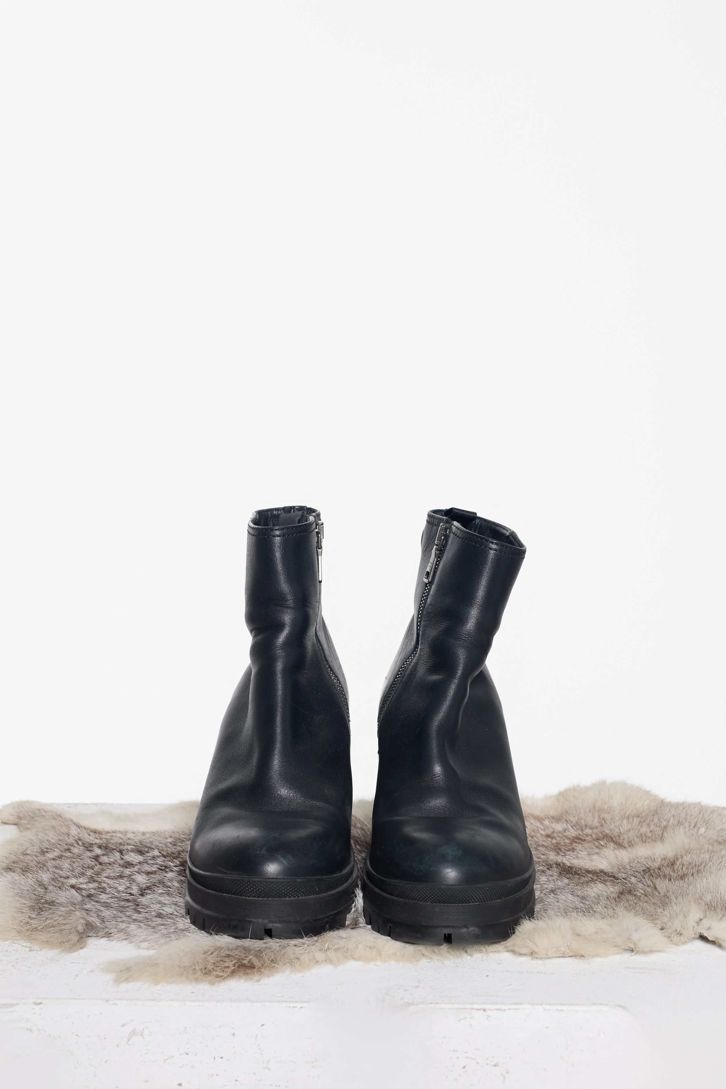 Front view of Prada black leather lug sole ankle boots