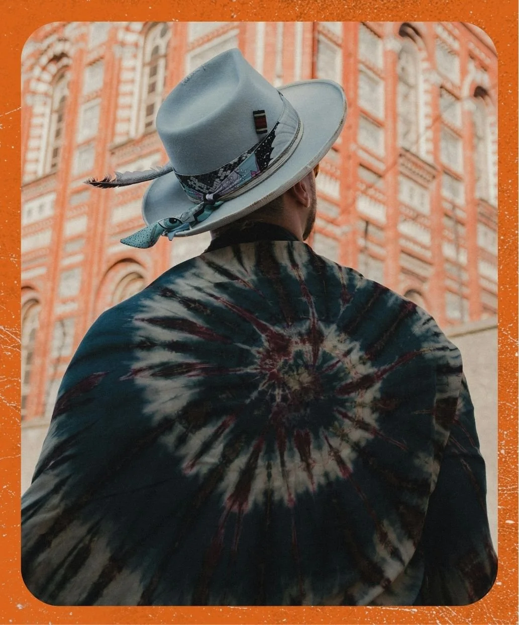 Person wearing tie-dye scarf and fedora hat