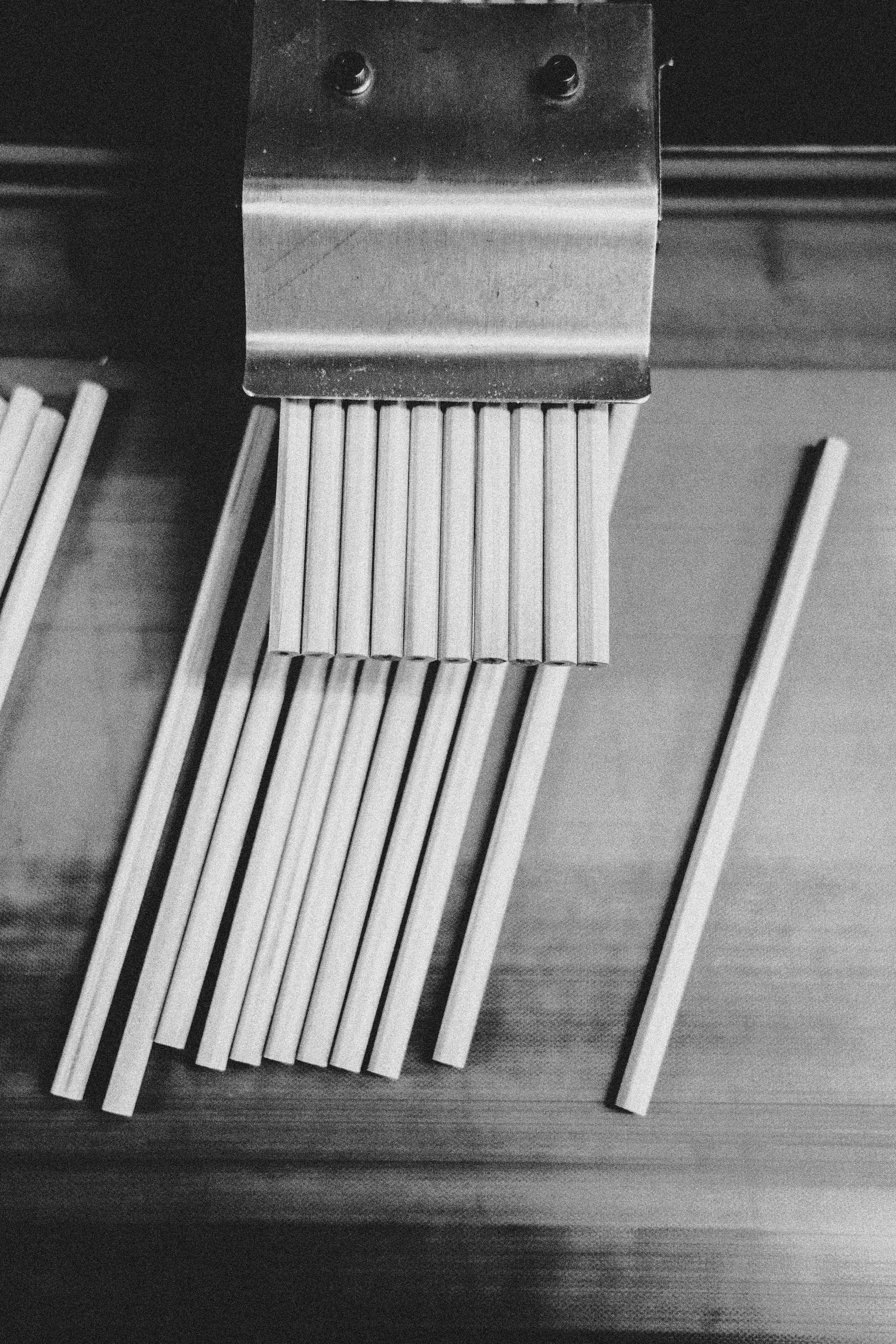 A set of wooden sticks or dowels placed on a wooden surface, with some grouped together and others separated.