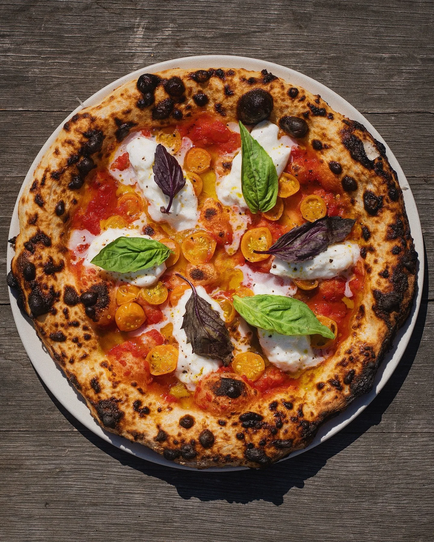 SUMMER MARGHARITA
crushed tomatoes, burrata, sungolds, basil oil

Fresh farmers market sungold tomatoes bring a sweet pop that meshes perfectly with our chilled burrata&mdash;our new summer pizza is here, and it might just be my favorite yet.
