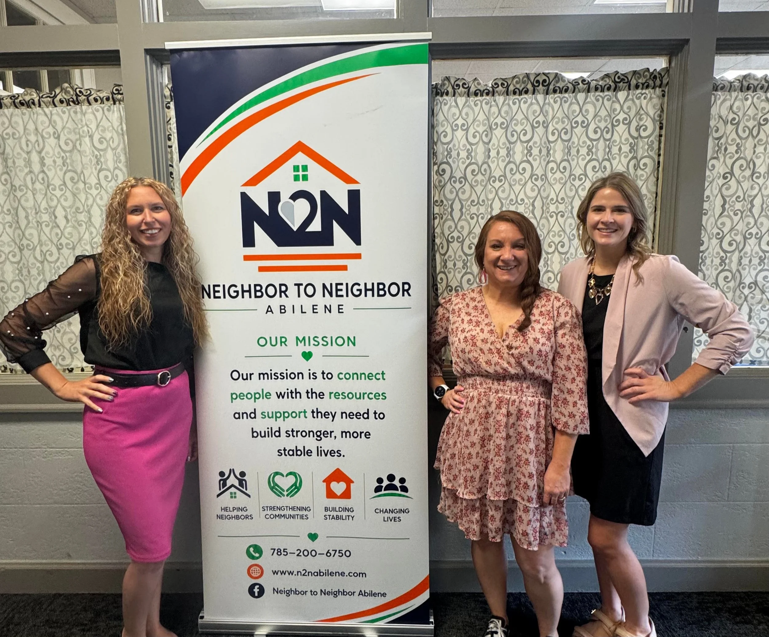 picture of neighbor to neighbor staff in front of informational banner
