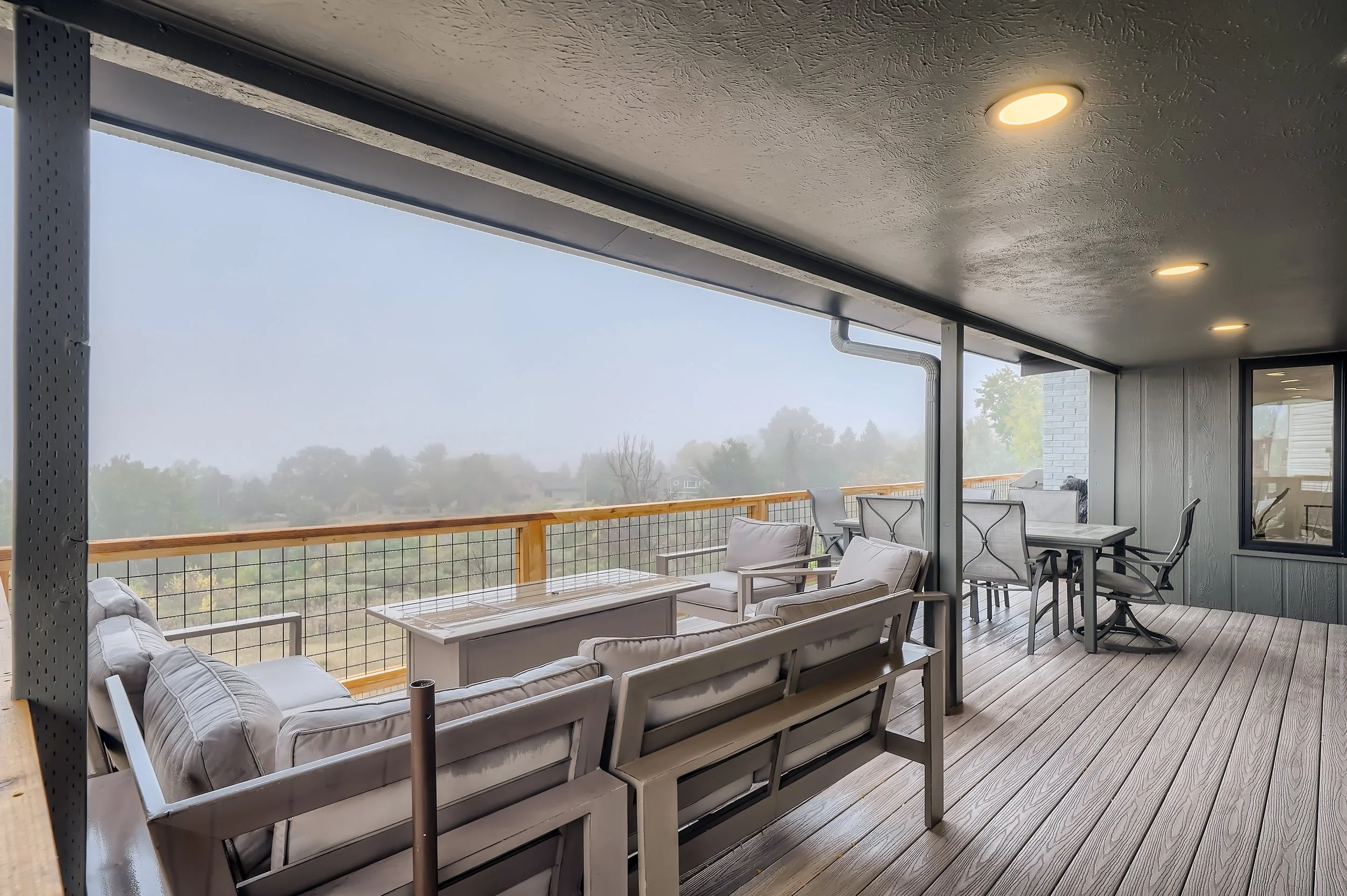 Covered composite deck with modern outdoor seating in Denver metro home renovation.
