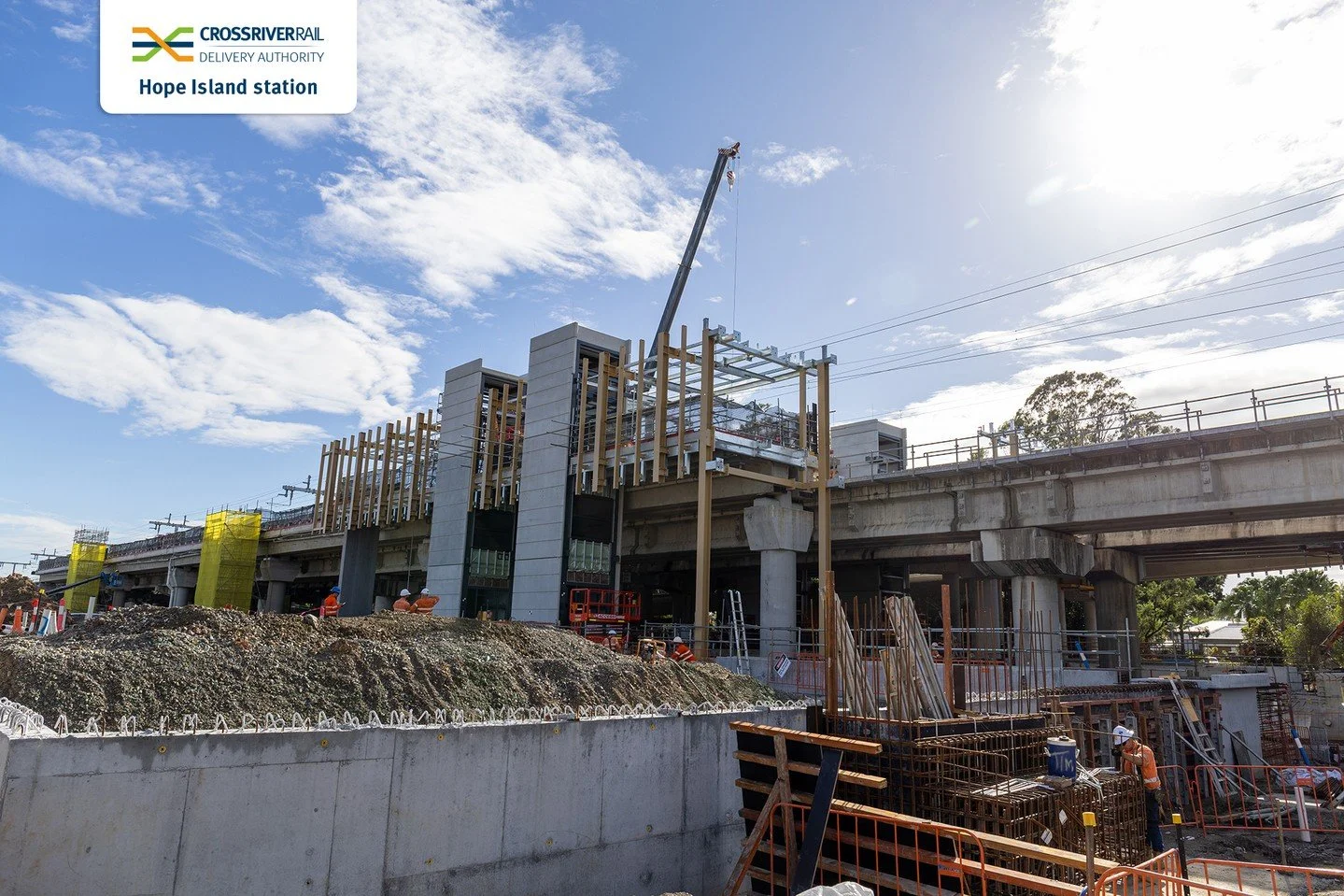 Construction site at Hope Island station with workers and building structures under development.