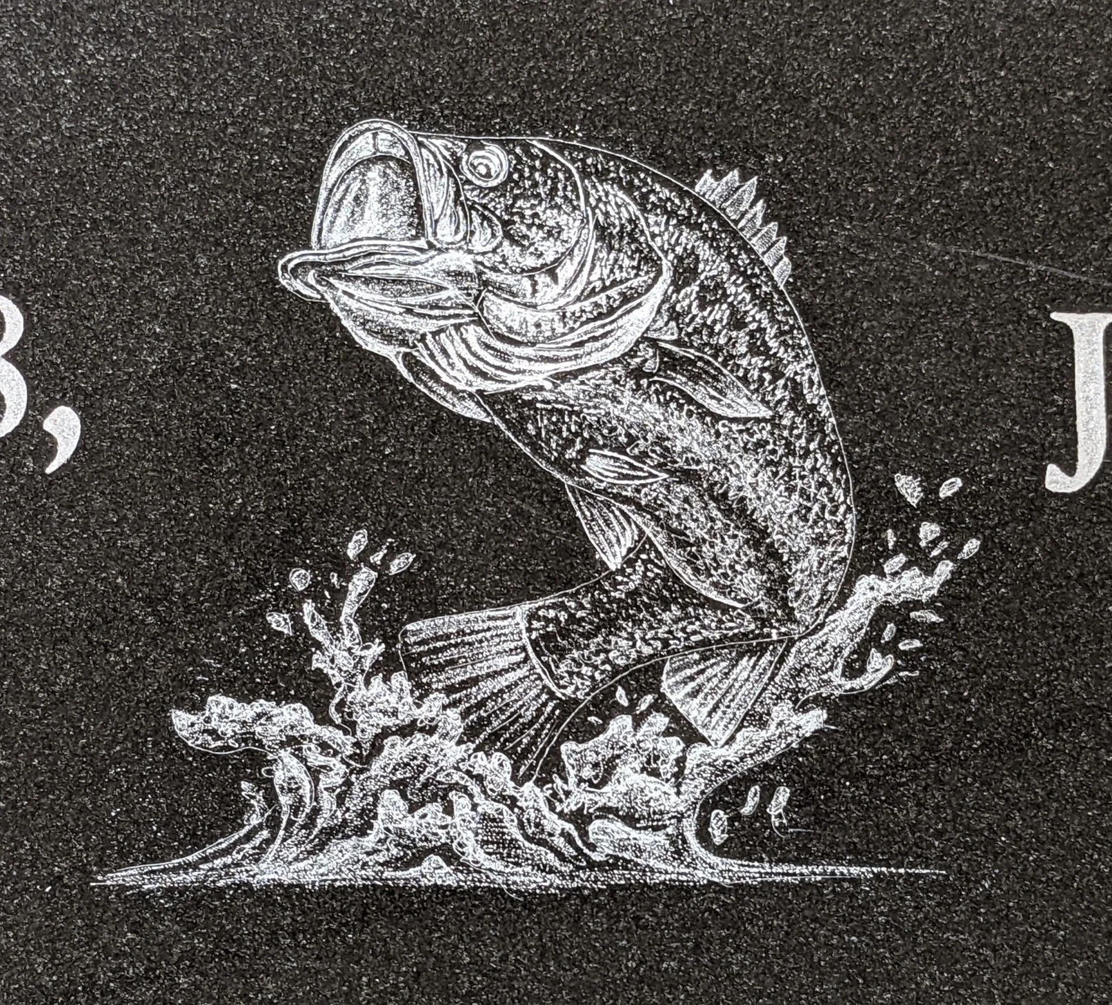 Custom monument etching of a bass fish on black granite. Timeless Tribute Memorials LLC Oshkosh, WI