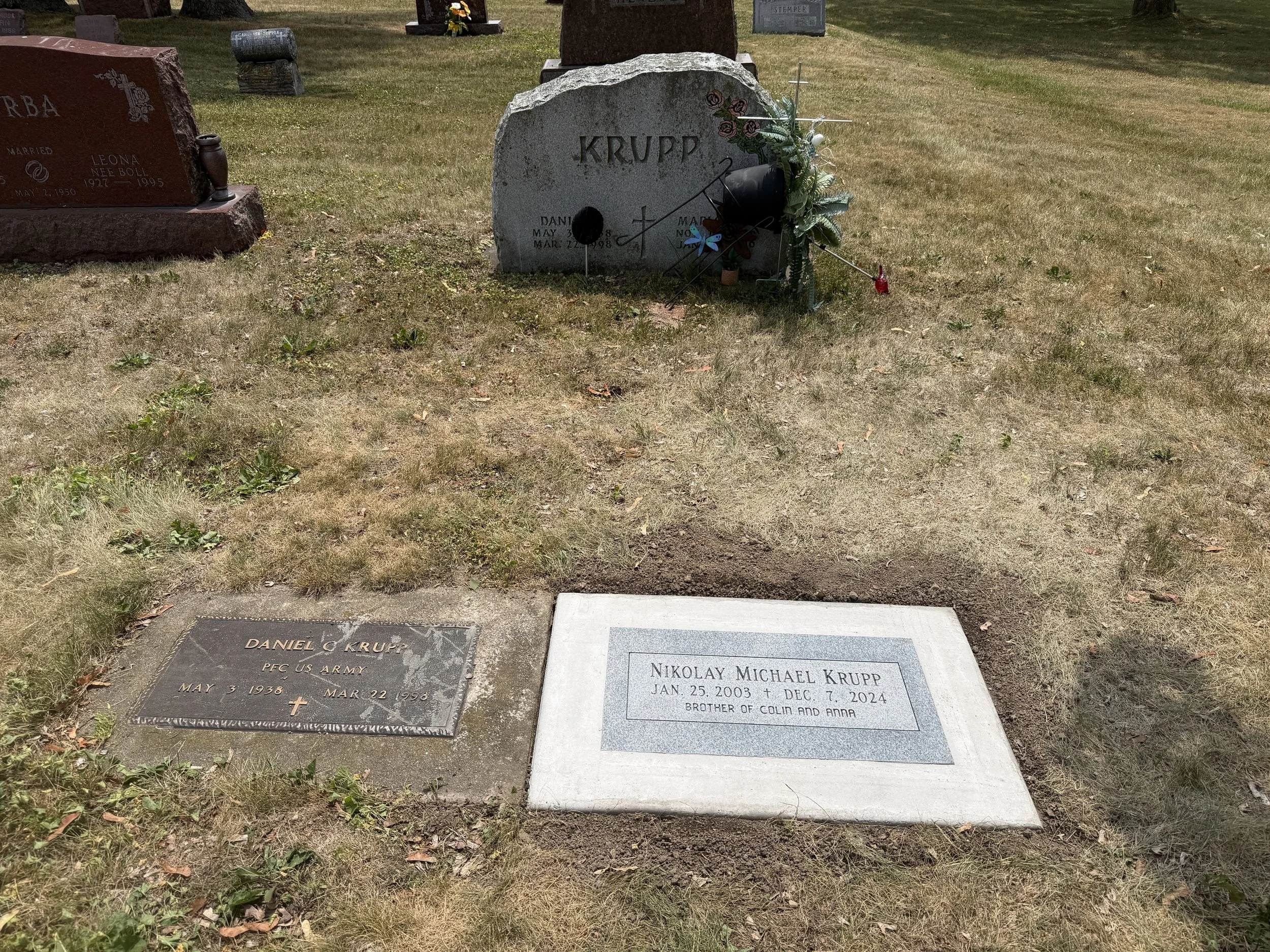 Flush single person grey granite marker set in concrete. Timeless Tribute Memorials LLC Oshkosh, WI
