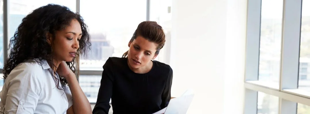 A professional leader engaged in a thoughtful one-on-one conversation with an employee in a modern office, conveying empathy, trust, understanding, accountability, and effective leadership.