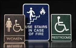 Accessibility restroom and emergency signage examples created as durable dimensional signage similar to architectural 3d bas relief plaques.