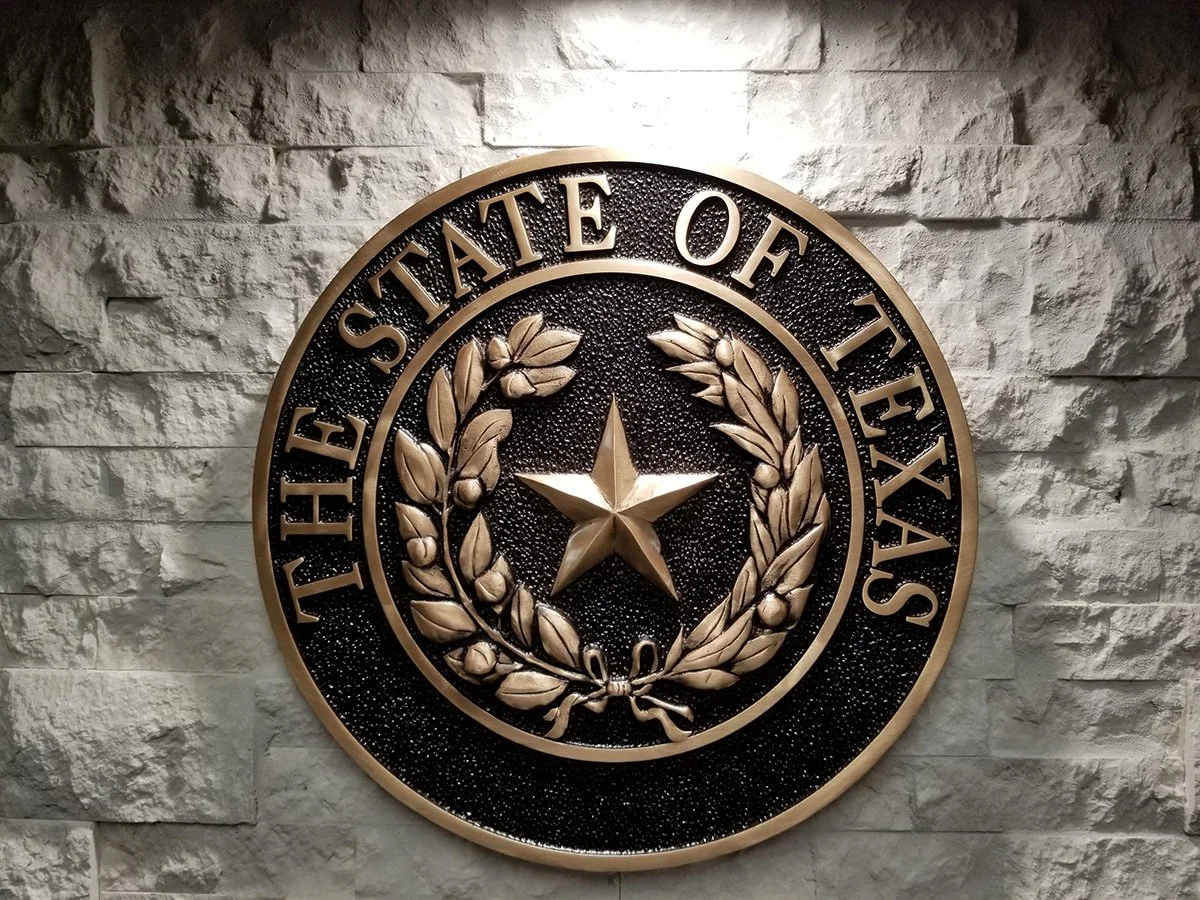 Architectural signage state seal wall plaque with cast metal detail, designed and produced by an experienced signage supplier.