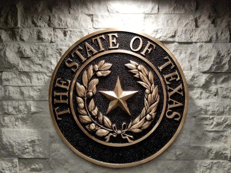 Custom bronze plaque featuring the State of Texas seal with a raised star, wreath, detailed lettering, and dark textured background.