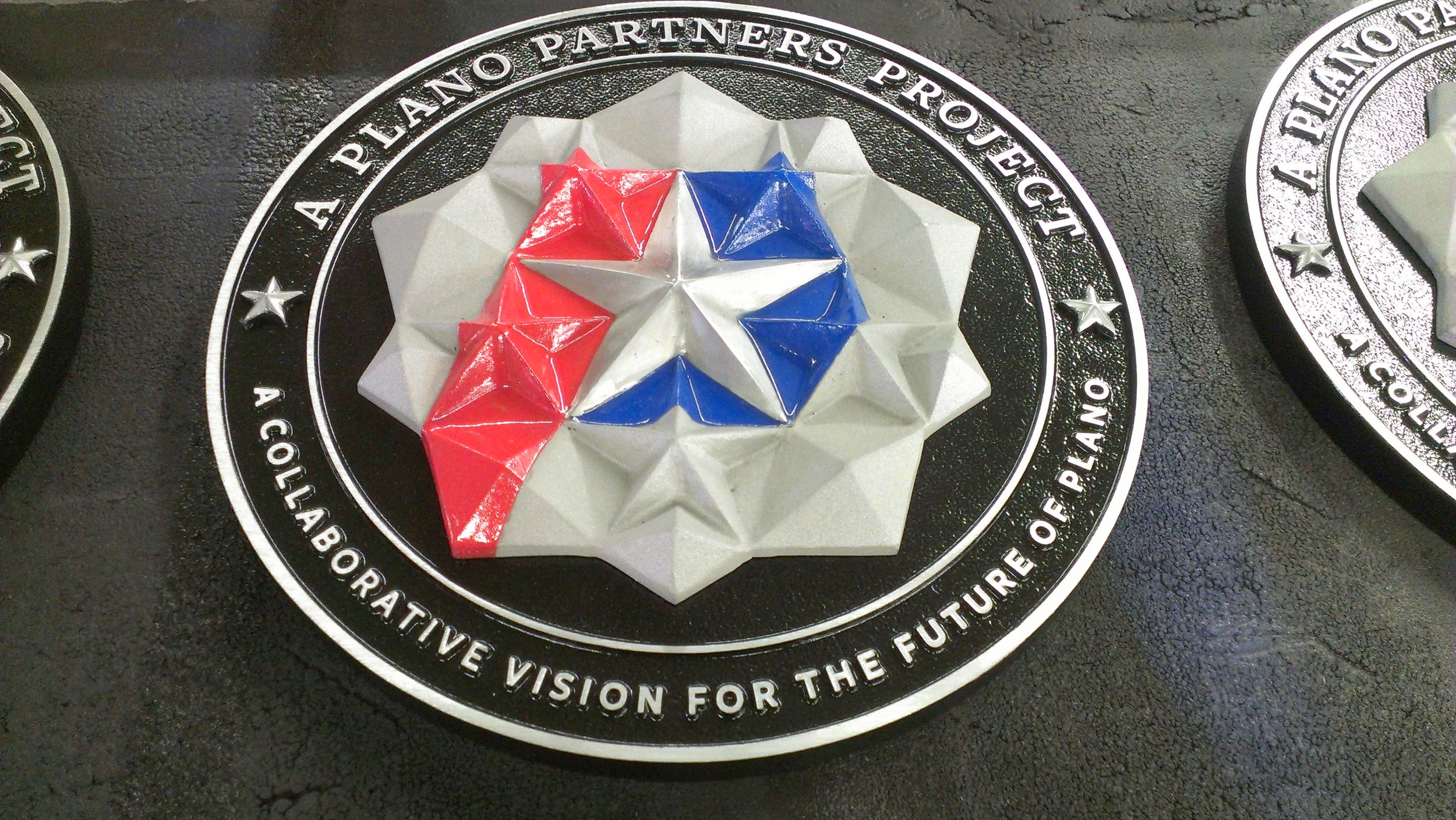 Plano Partners Project emblem created as a custom 3d bas relief plaque featuring sculpted geometric design and color detailing typical of dimensional bas relief plaques.