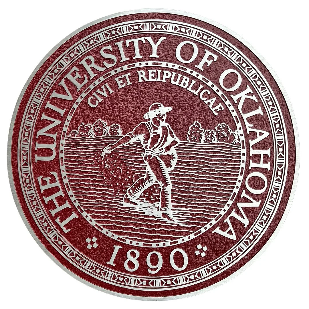 Custom university signage featuring the University of Oklahoma seal in crimson and silver with detailed raised metal artwork.