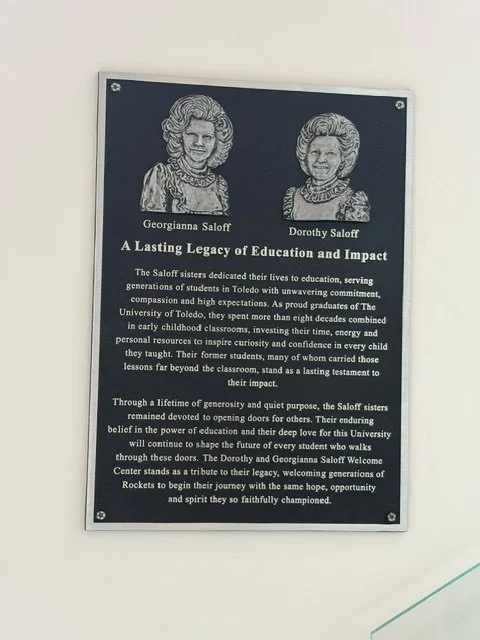 Custom memorial plaques with portrait relief and inscription, installed as a permanent outdoor metal memorial plaque.