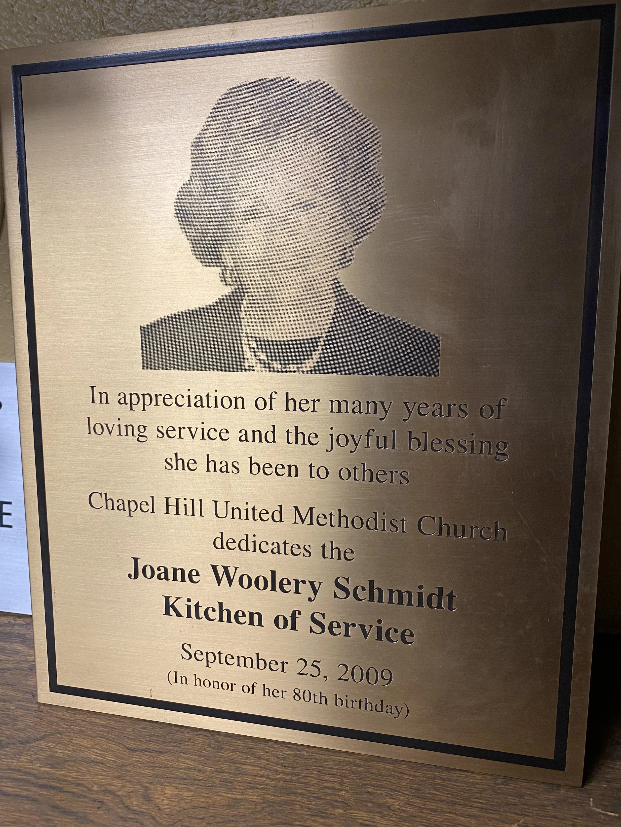 Custom memorial plaques dedicated to Joane Woolery Schmidt for church service, designed as an elegant metal memorial plaque with engraved portrait and inscription.