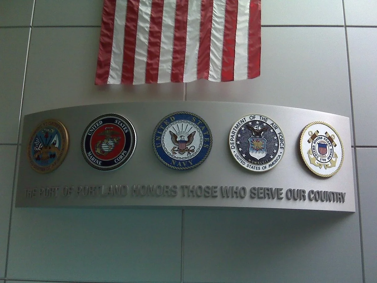 Architectural signage military service wall display featuring branch seals and dedication text, crafted by a professional signage supplier.
