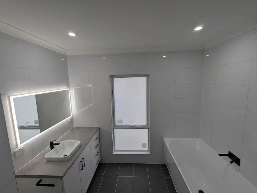 Completed bathroom renovation with freestanding bath and LED mirror by Massey Constructions Bendigo