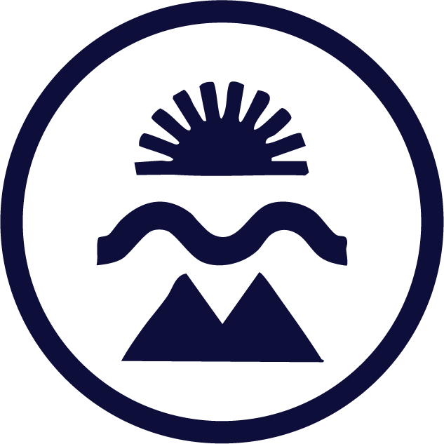 A dark-blue circular emblem featuring a sun rising over mountains with a wavy water line below, representing in lieu’s natural source, purity, and heritage-inspired identity.