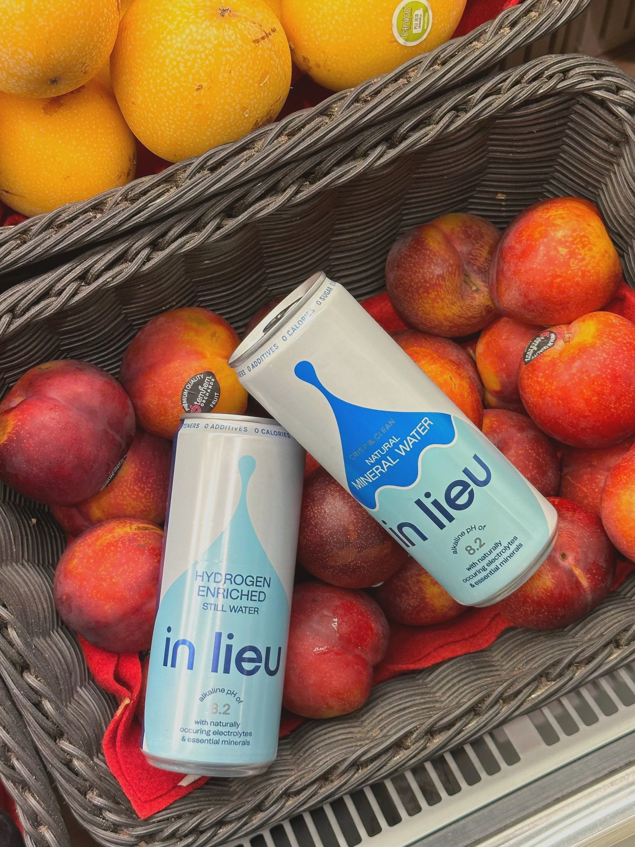 A basket of red and yellow apples with two bottles of in lieu mineral water placed on top.