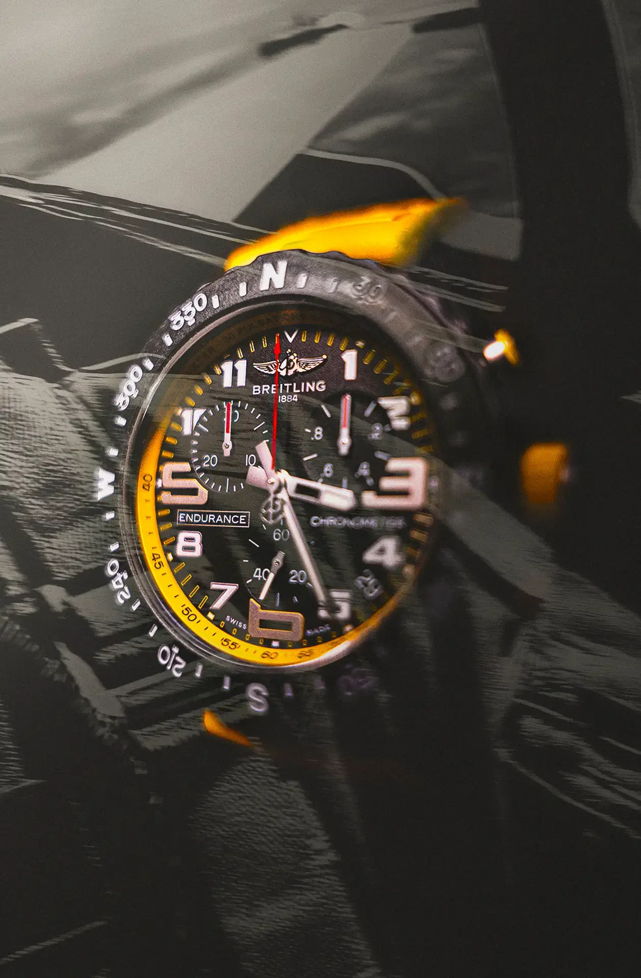 Montre Breitling noire avec cadran noir, chiffres éclairés, bracelet en caoutchouc, superposé à une image d'une banane jaune, tous deux sur un fond noir.