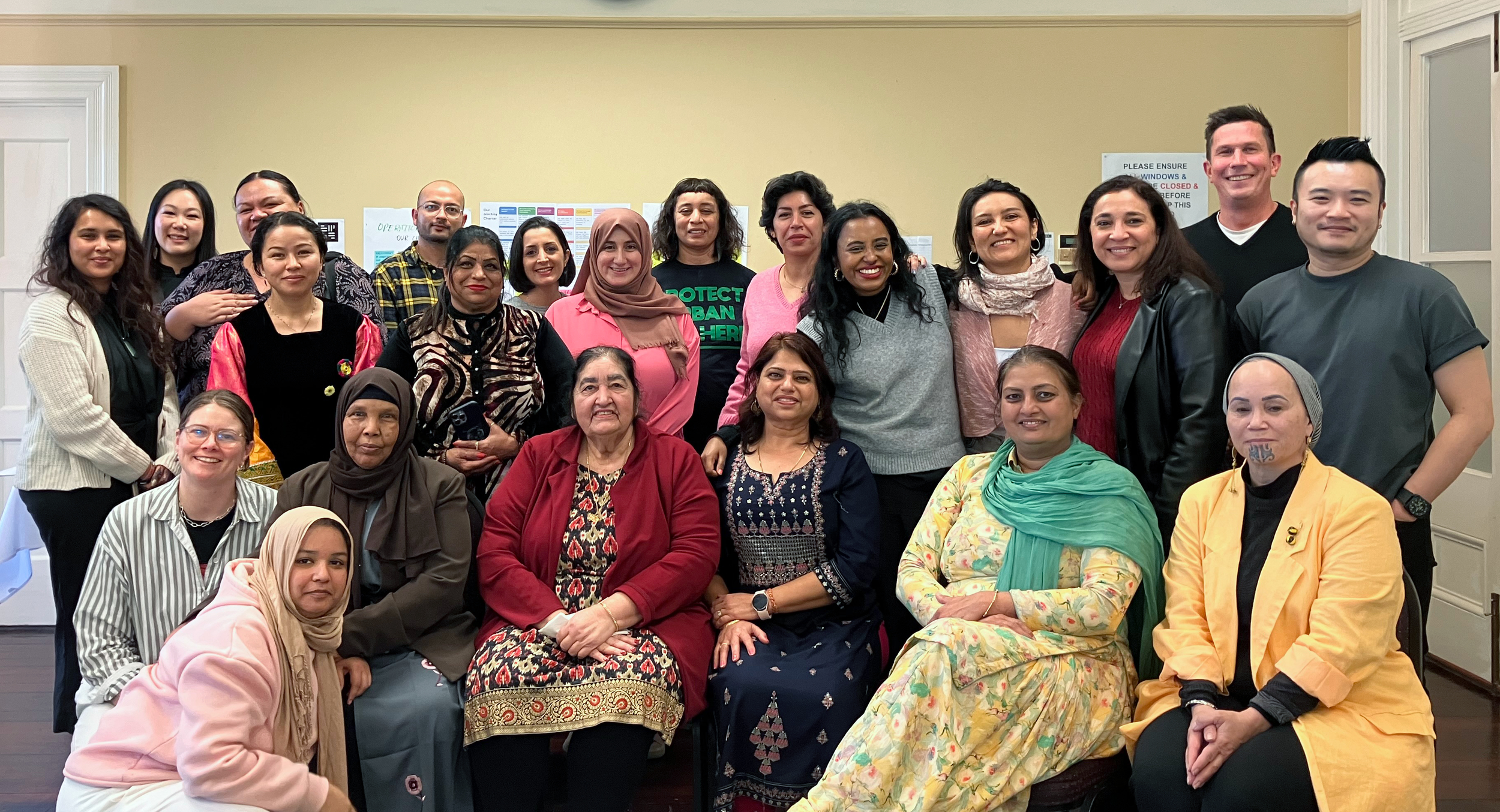 Group of diverse adults posing for a photo in an indoor setting.
