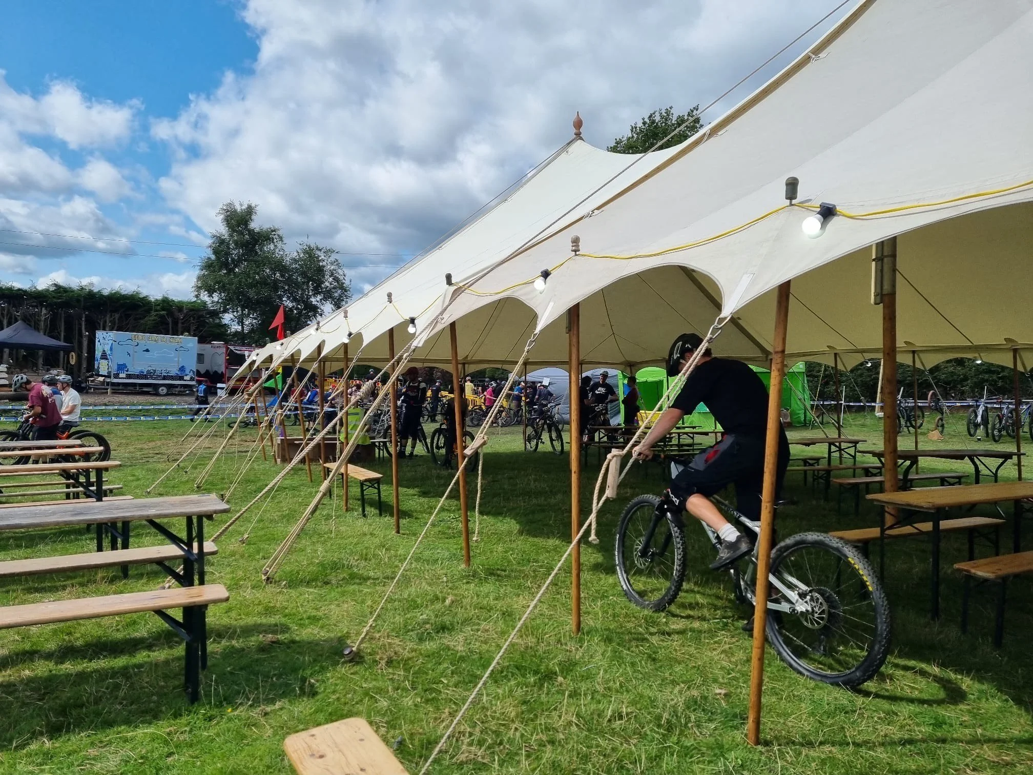 mountain biker riding through a petal pole festival marquee in Bollington