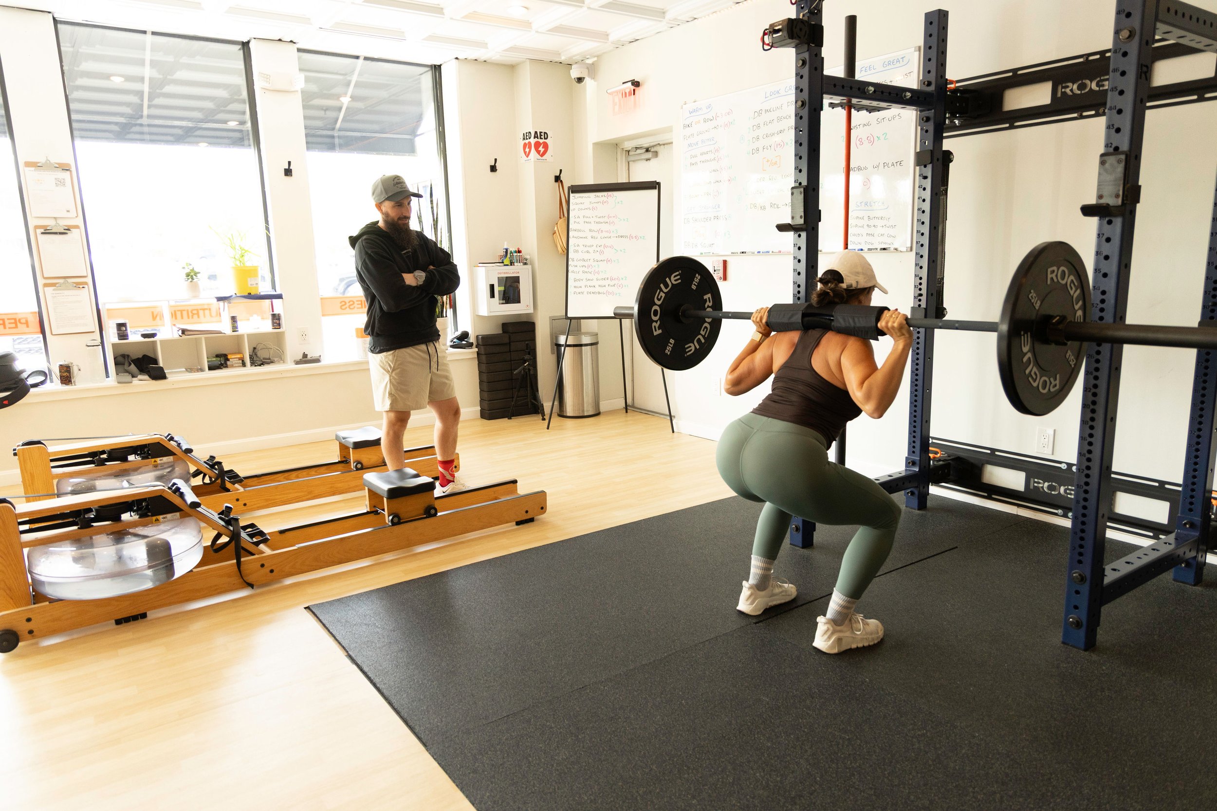 Woman doing back squat during semi private training at the genesis fit in marshfield ma