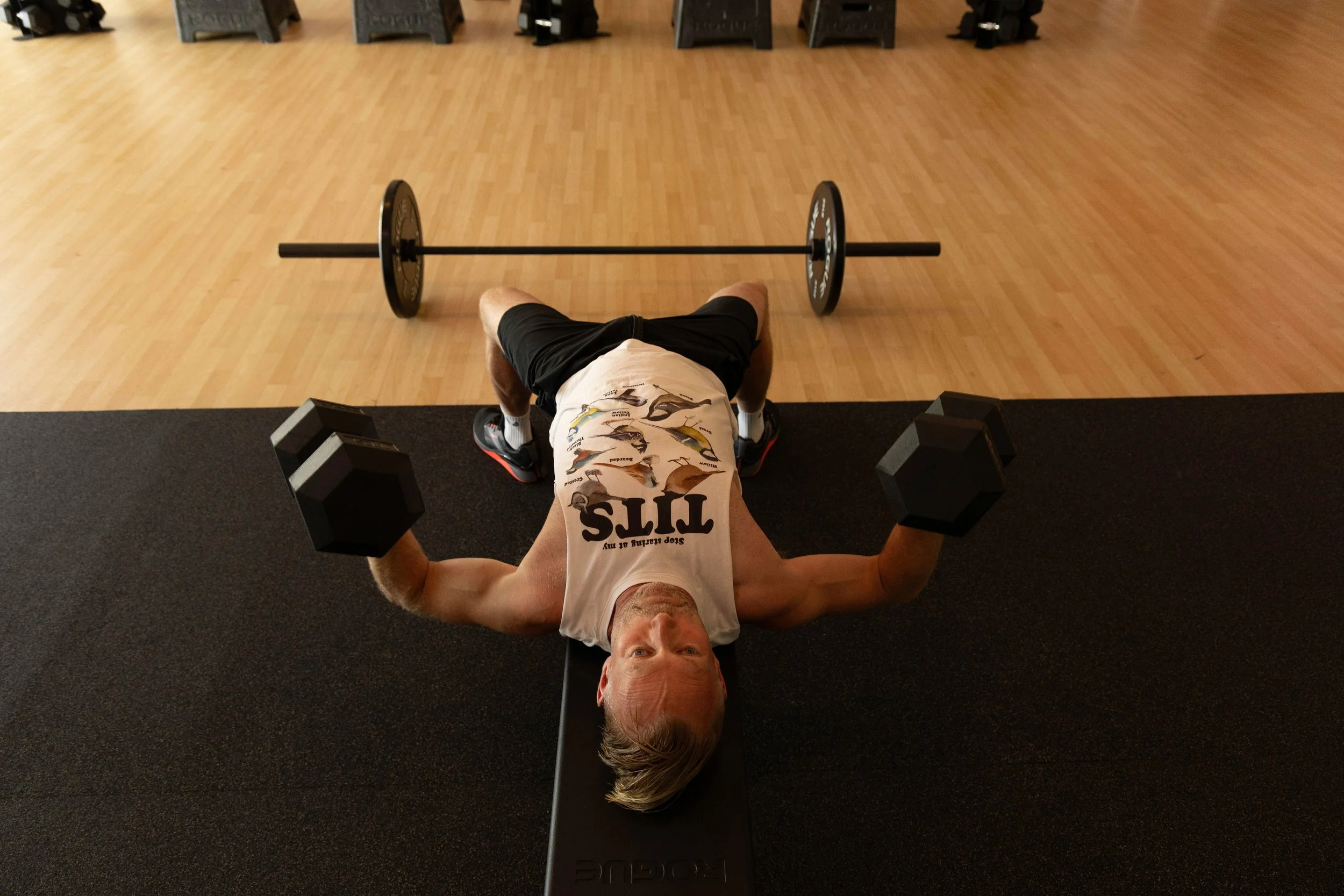 Client at The Genesis Fit, doing dumbbell bench press with heavy weights, building strength, and increasing mobility during his 6-1 semi-private training