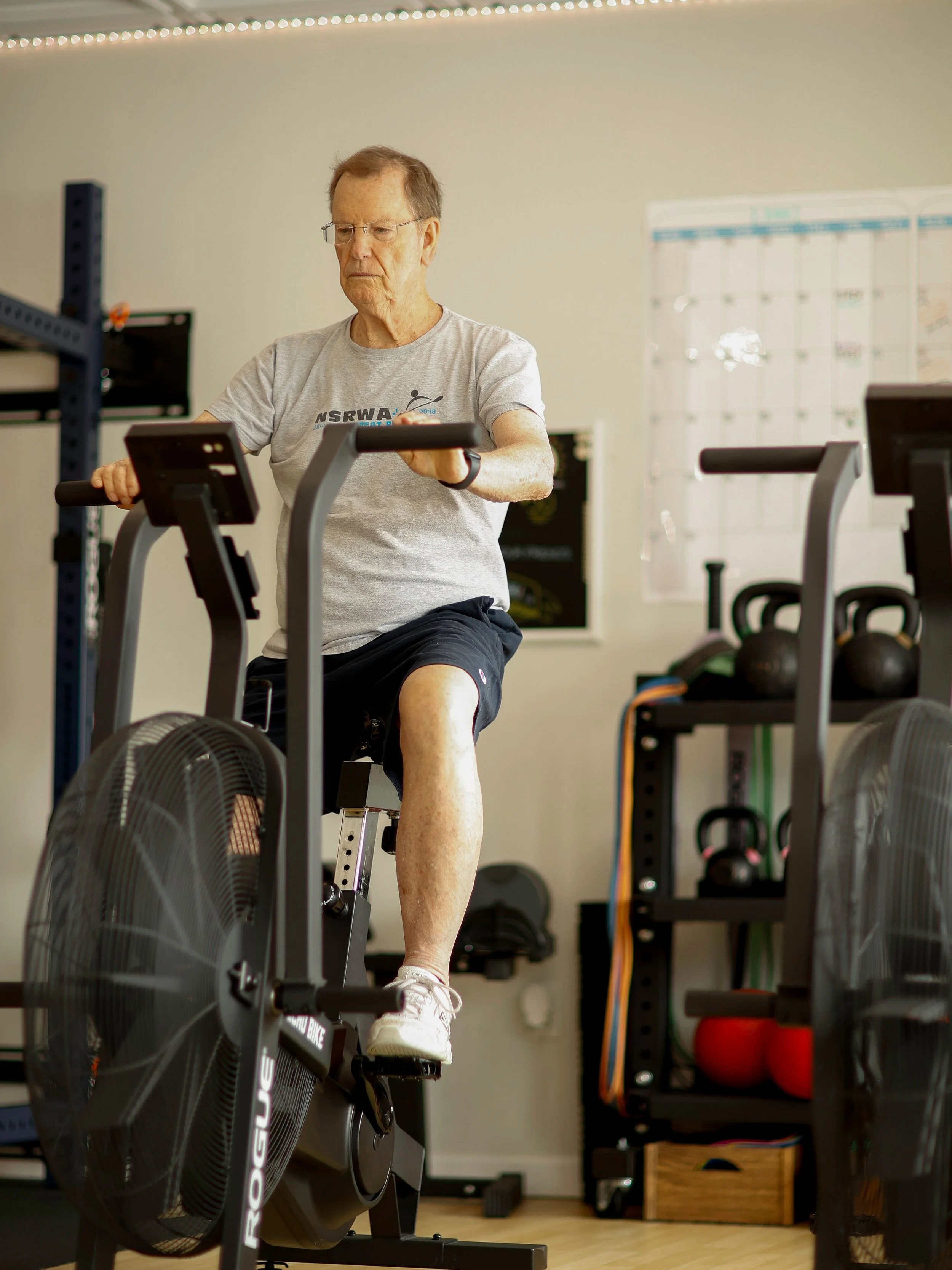 Senior doing knee pre-surgery work on a rogue bike at the genesis fit in marshfield Ma.