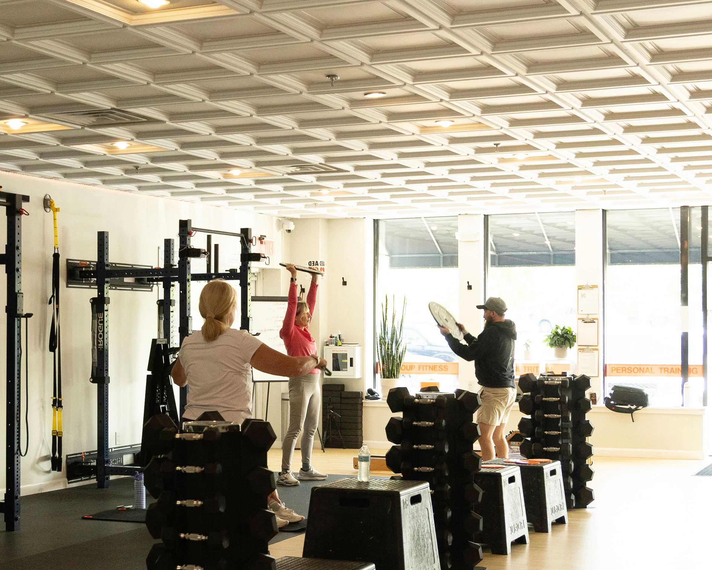 A couple of seniors being trained by coach garrett in a semi-private enviornment. Coach garrett is demonstrating movement while the group watches.
