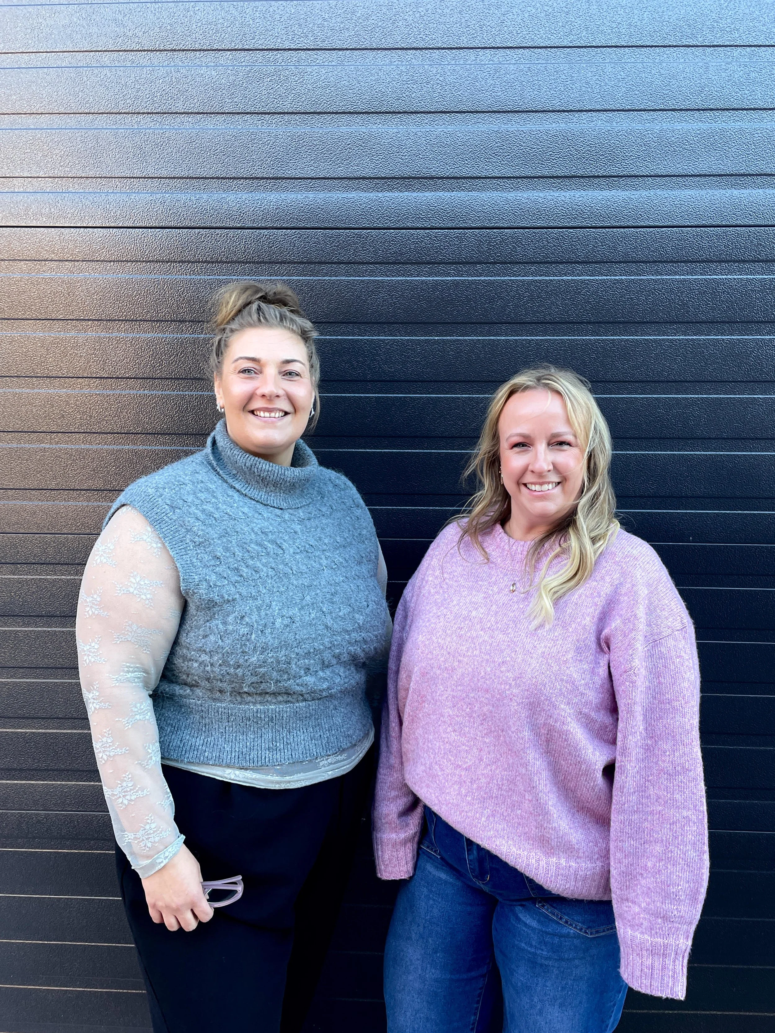 Erin and Shannon, small business owners and faces behind The Haven Collective in Green Bay, Wisconsin, smiling outside their event space