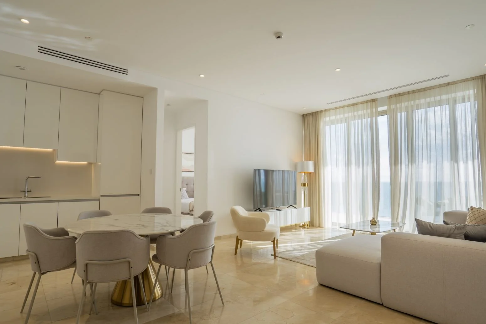 Open-plan living area of a 2-bedroom apartment at Soho Resort Paphos with floor-to-ceiling windows and panoramic Mediterranean Sea views.