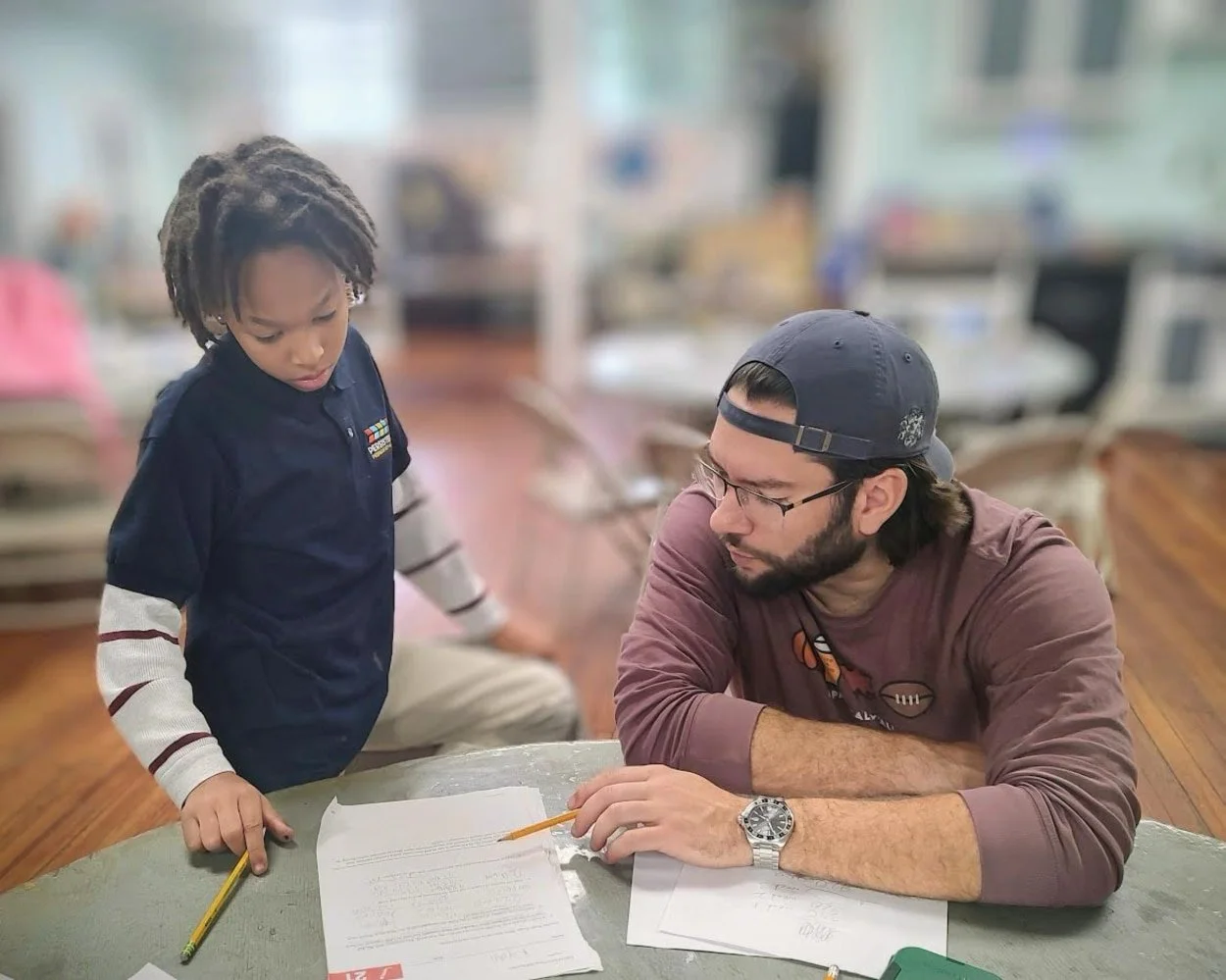 A man helping a young boy with his homework