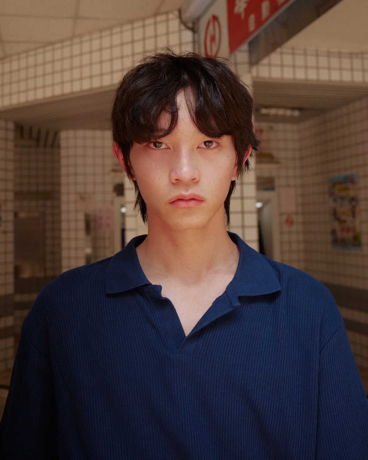 Male model in a navy polo shirt photographed in a Taipei street for Pedro Márnez fashion editorial