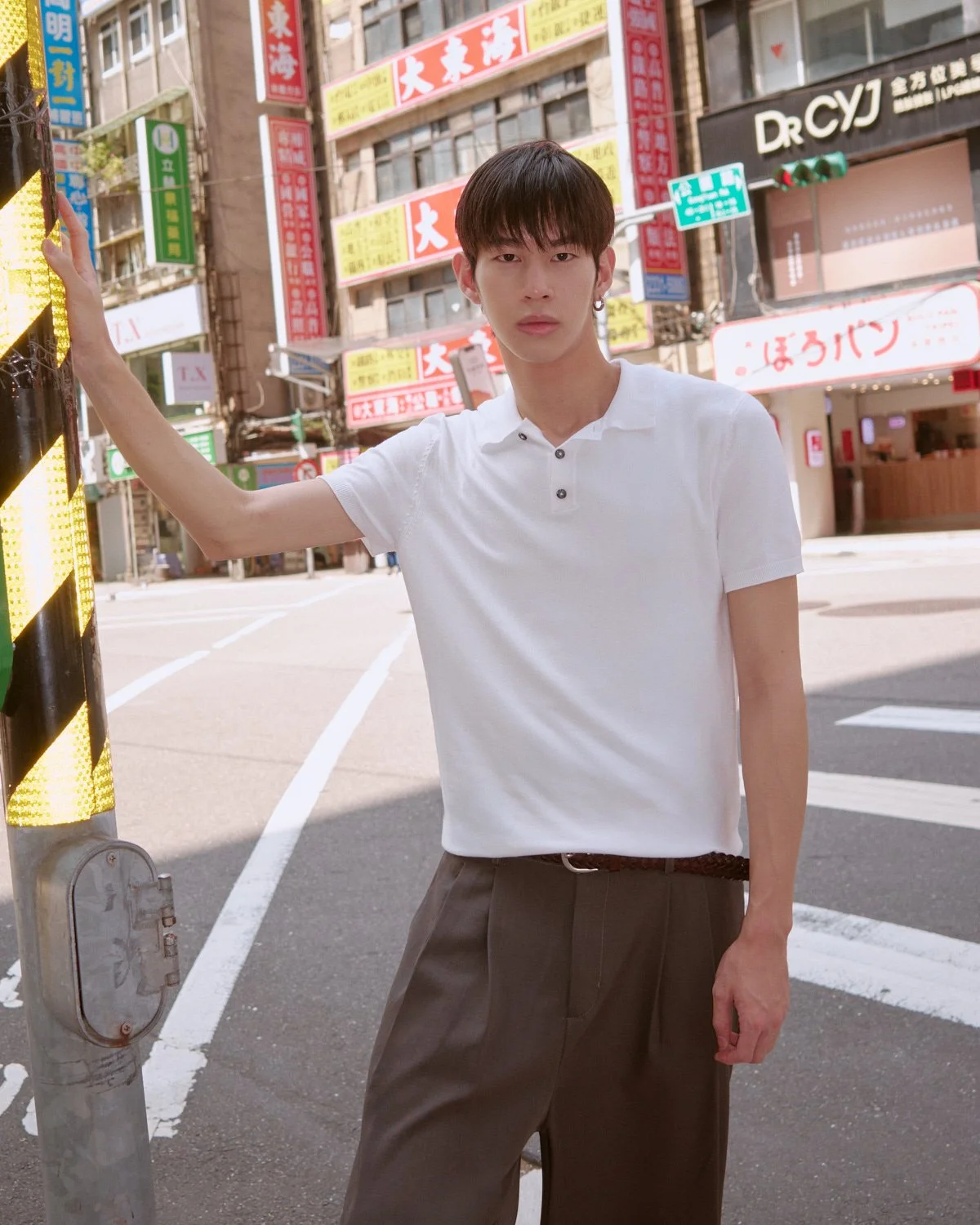 Male model in a white polo shirt photographed on a Taipei street by Pedro Márnez