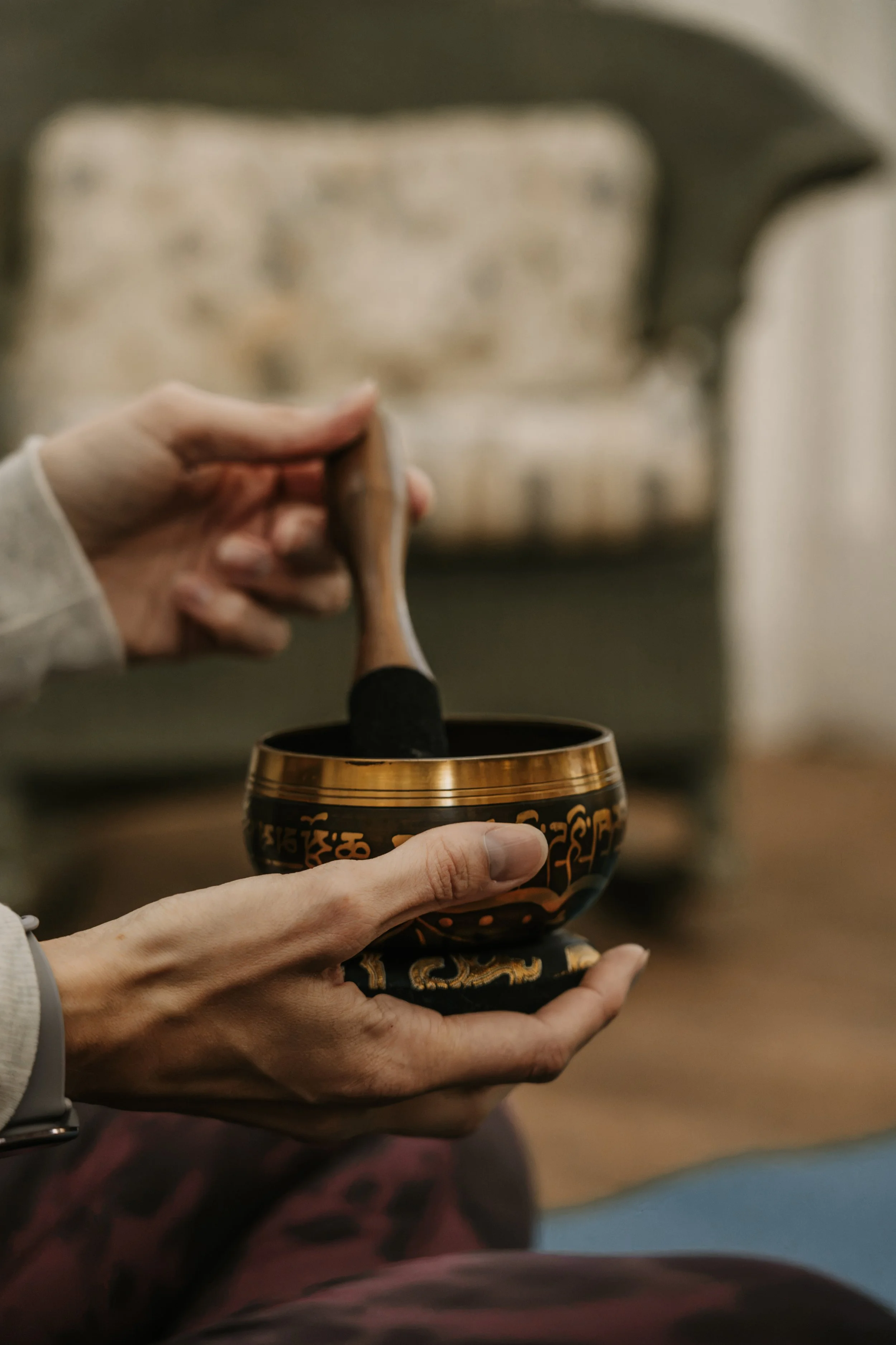 Hands holding a brass singing bowl